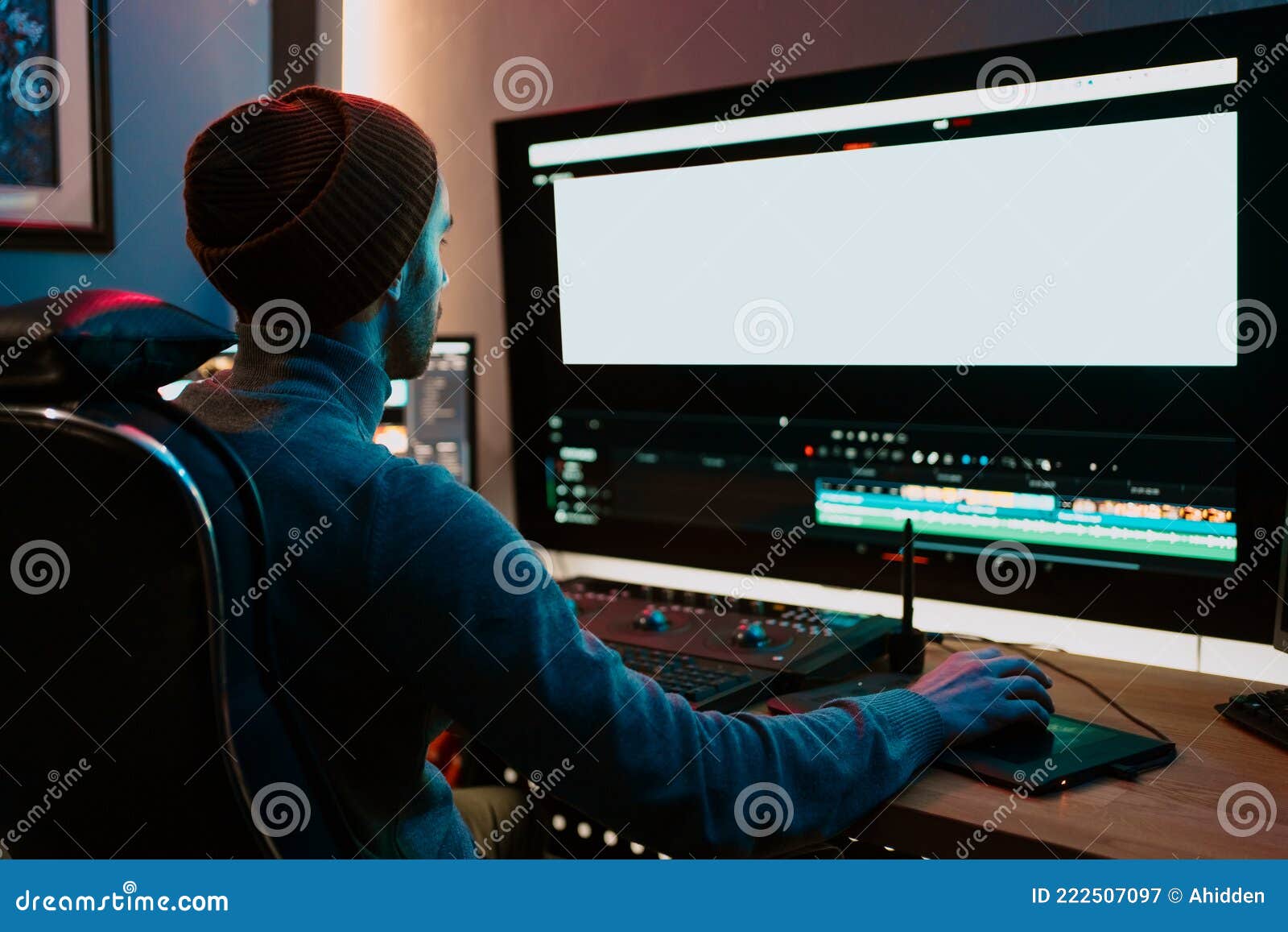 male video editor working on his personal computer with big blank display