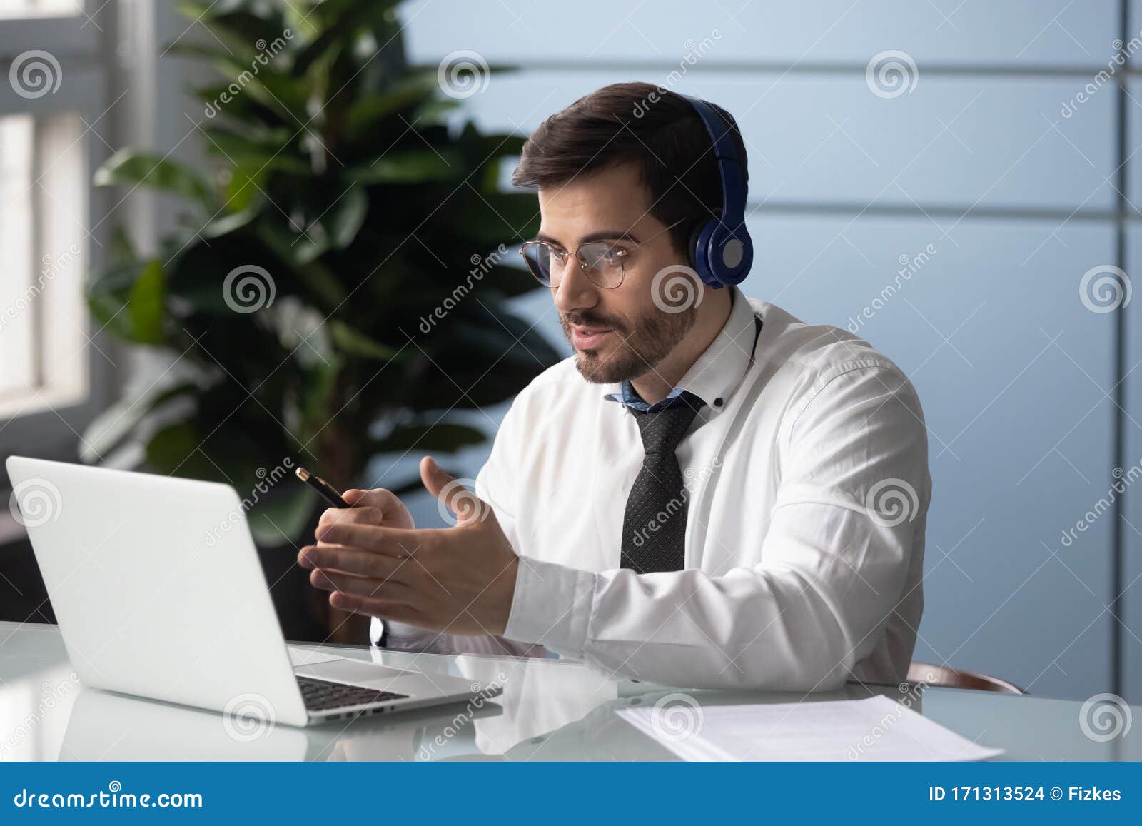 businessman in headphones makes videocall chatting with partner consulting client