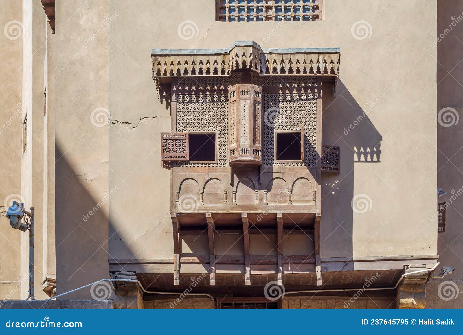 mamluk era style oriel windows with interleaved wooden grid - mashrabiya, on shabby wall