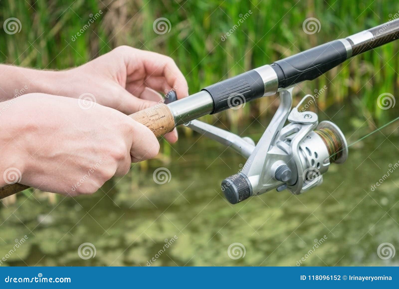 https://thumbs.dreamstime.com/z/man%C3%A2%E2%82%AC%E2%84%A2s-hand-fishing-rod-feeder-reel-river-bank-green-reeds-fisherman-s-mounted-english-style-118096152.jpg