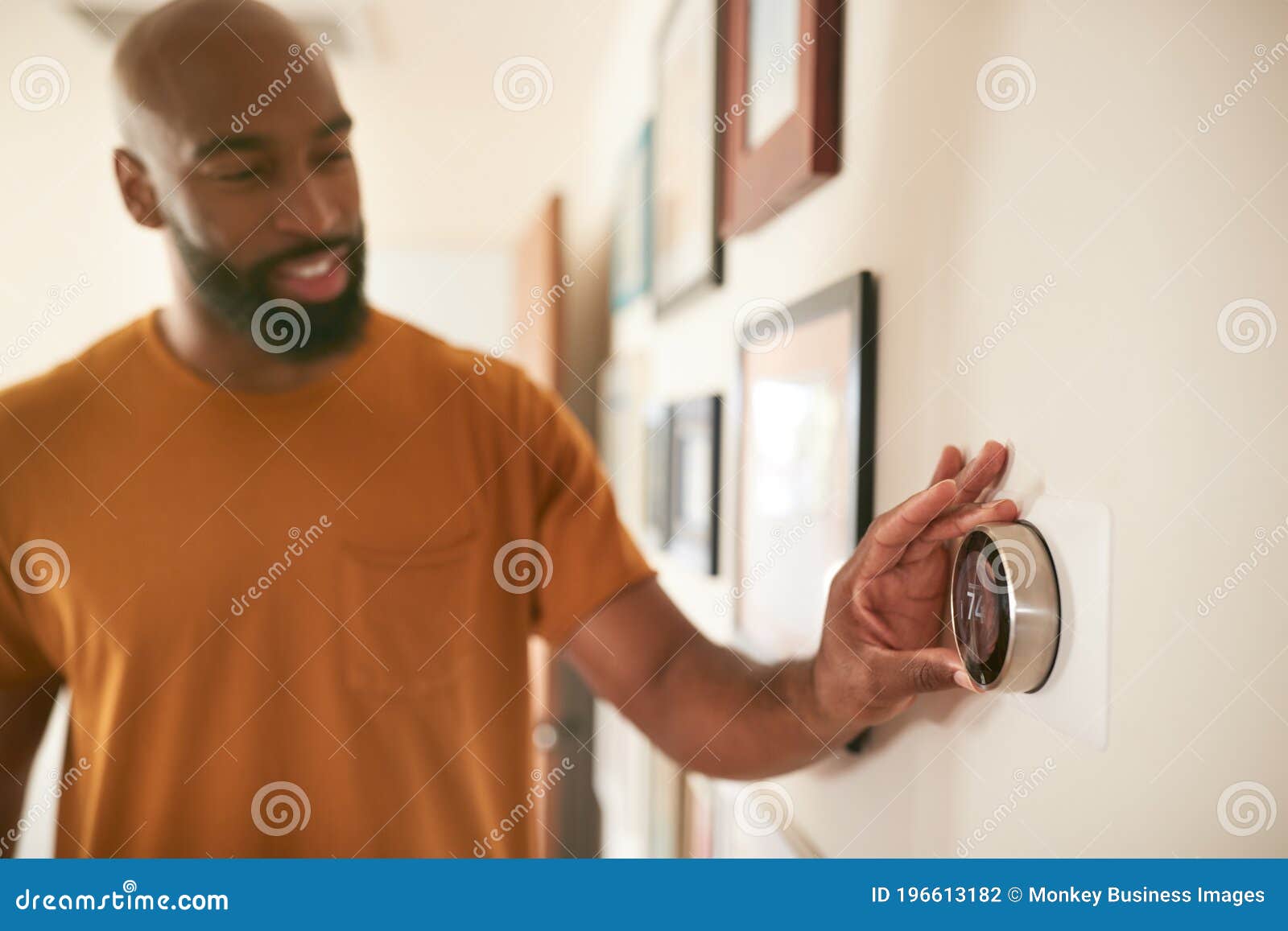 man adjusting digital central heating thermostat at home