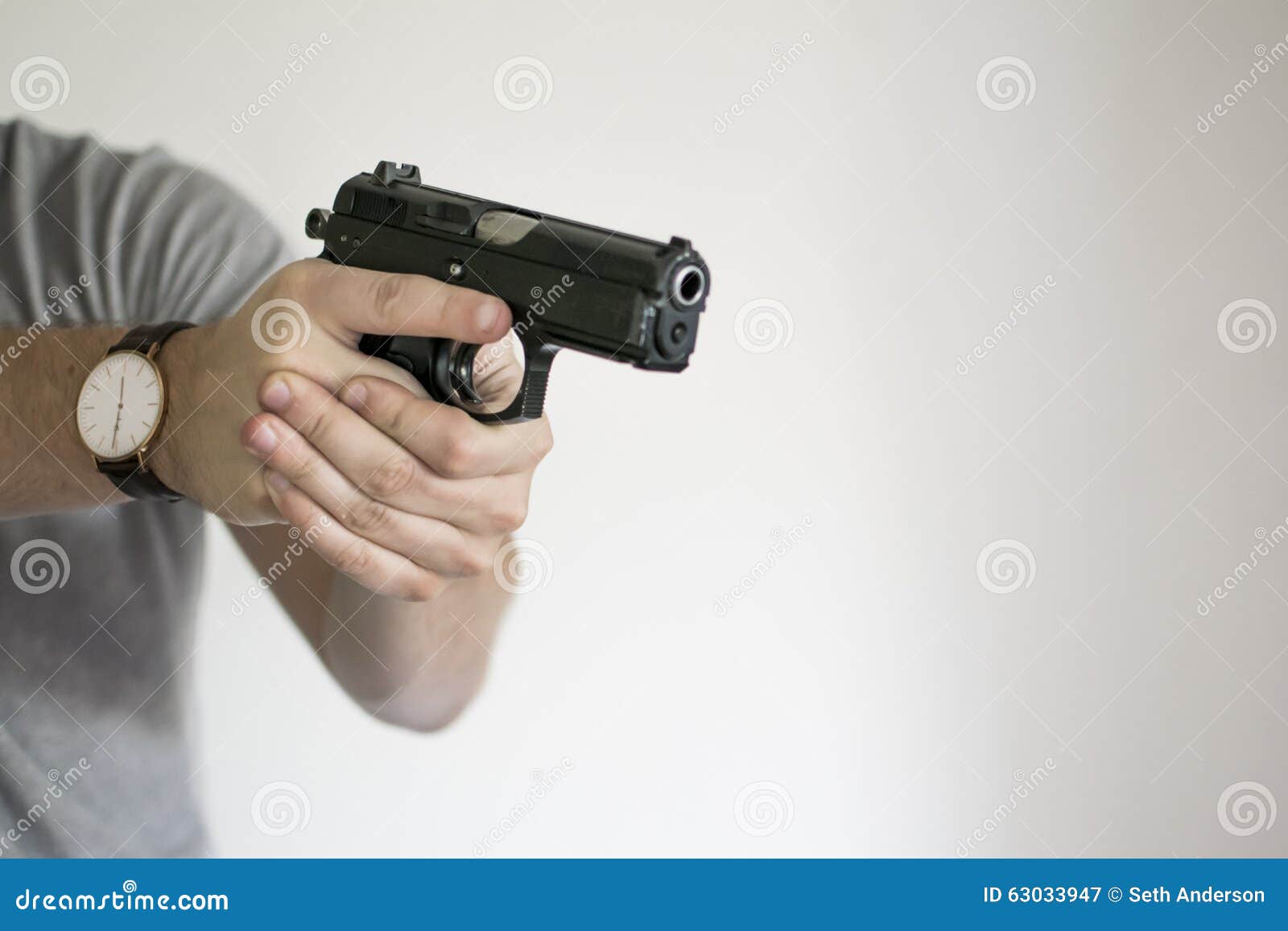 man aiming handgun from holster in self defense