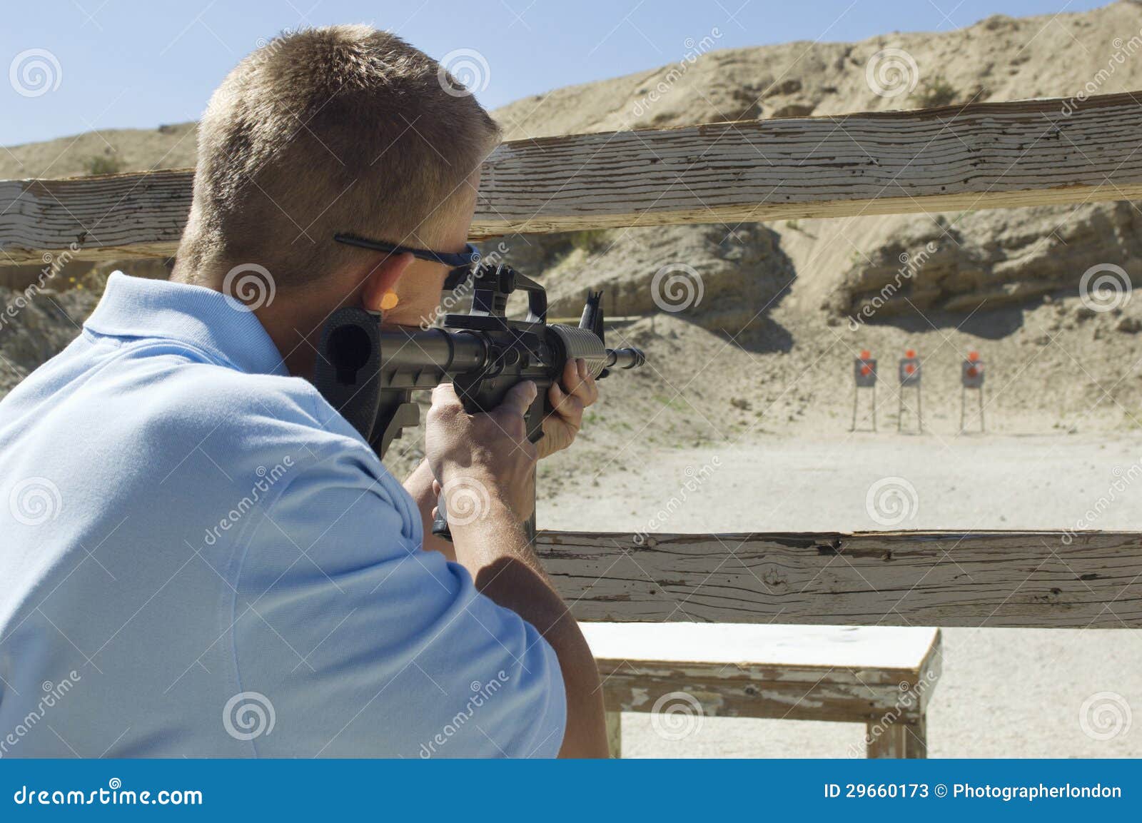 man aiming machine gun at firing range
