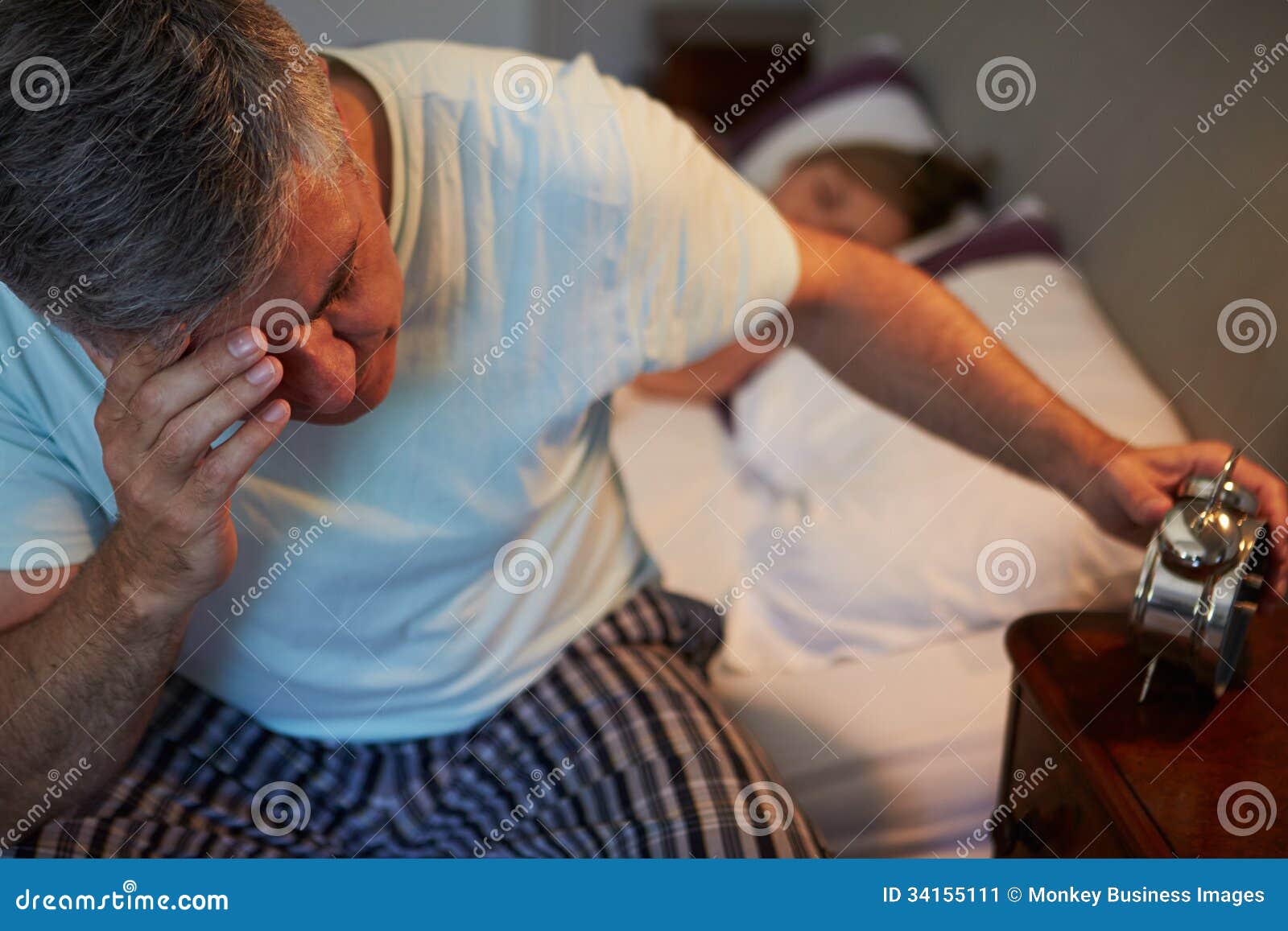 man awake in bed suffering with insomnia