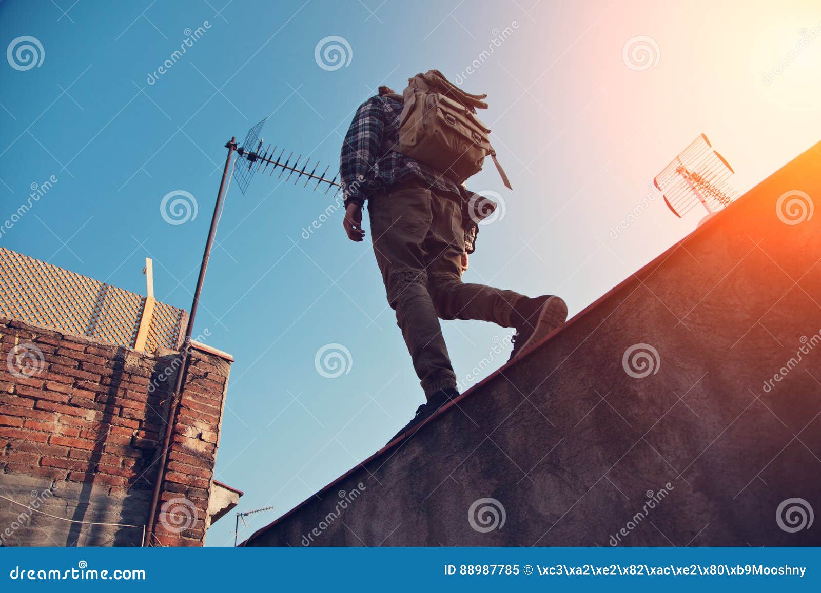 Man With Backpack Walking Over High Wall On The Edge On The - 