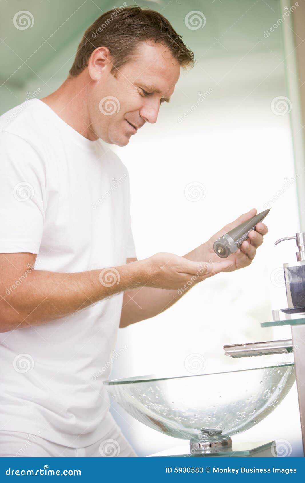 man in bathroom applying aftershave