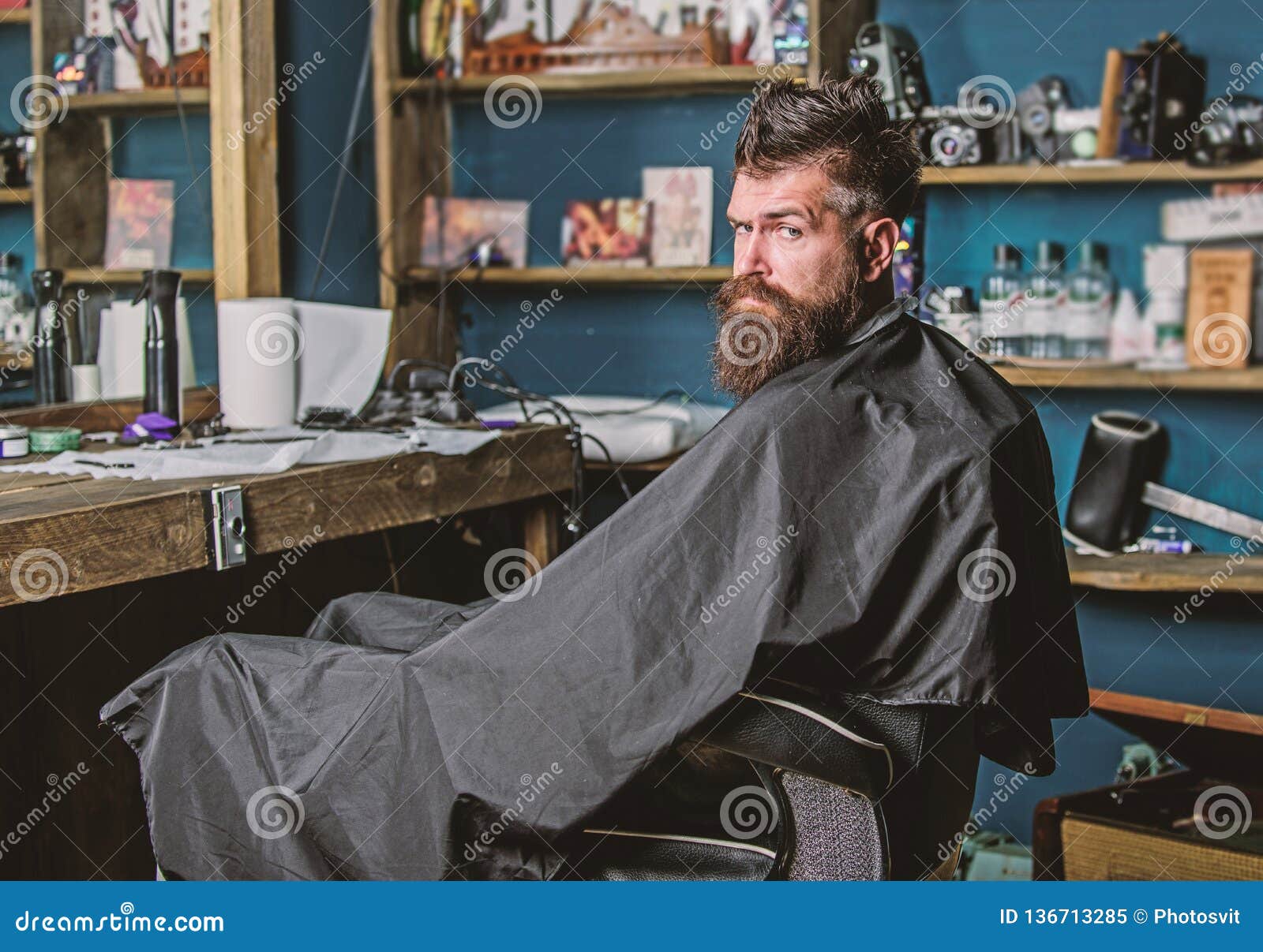 Man with Beard Covered with Black Cape Sits in Hairdressers Chair in ...