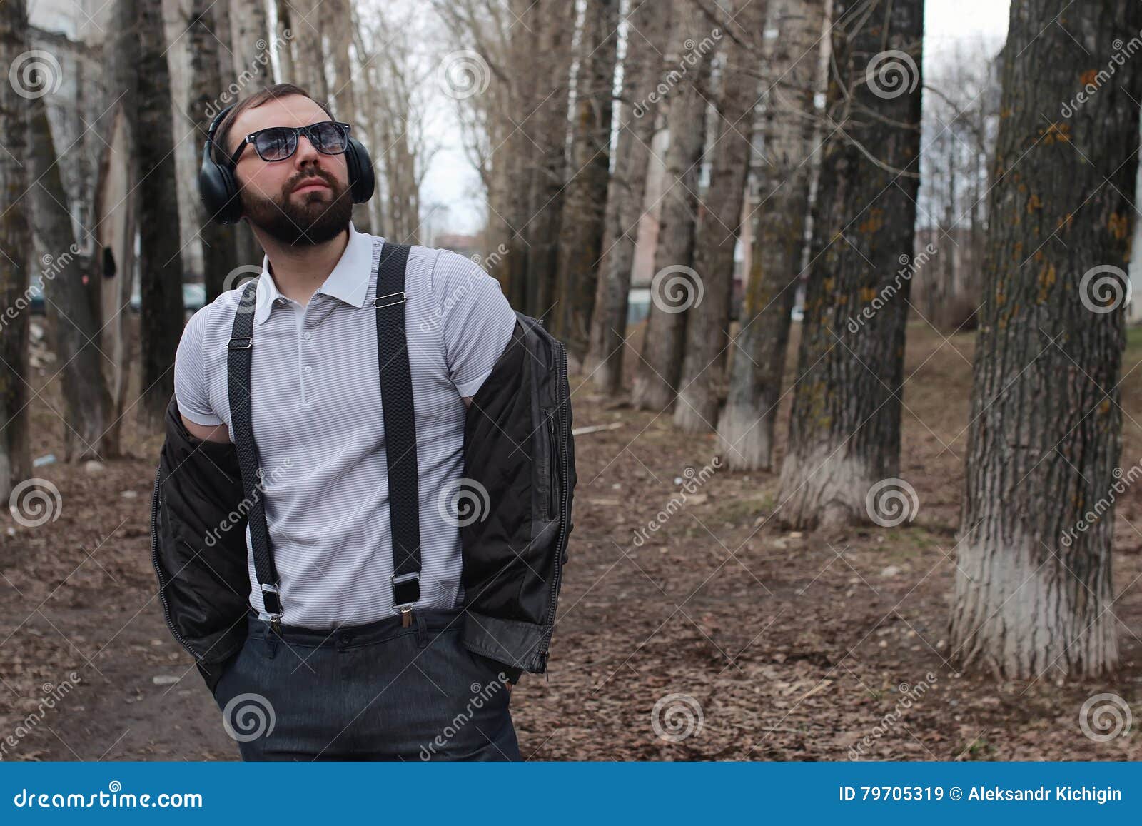 man with beard and headphones in the park