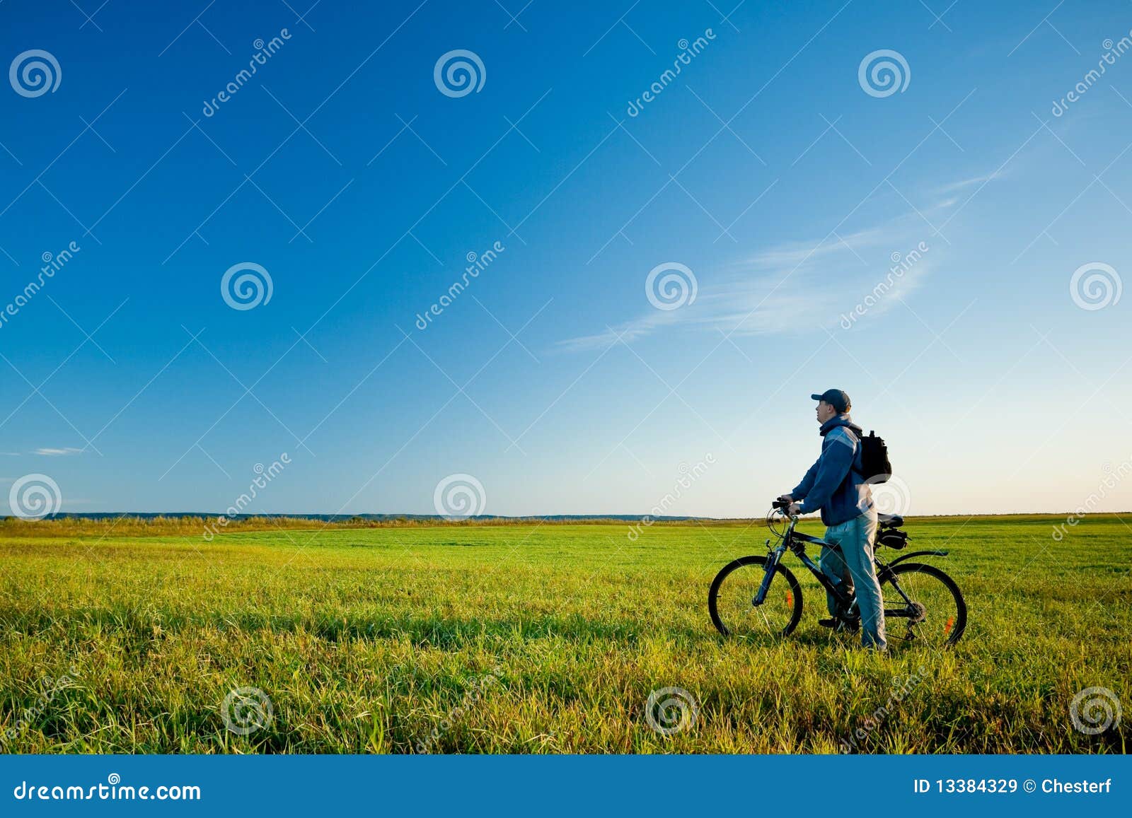 Man on bike in field stock image. Image of landscape - 13384329, image size:1600x1157