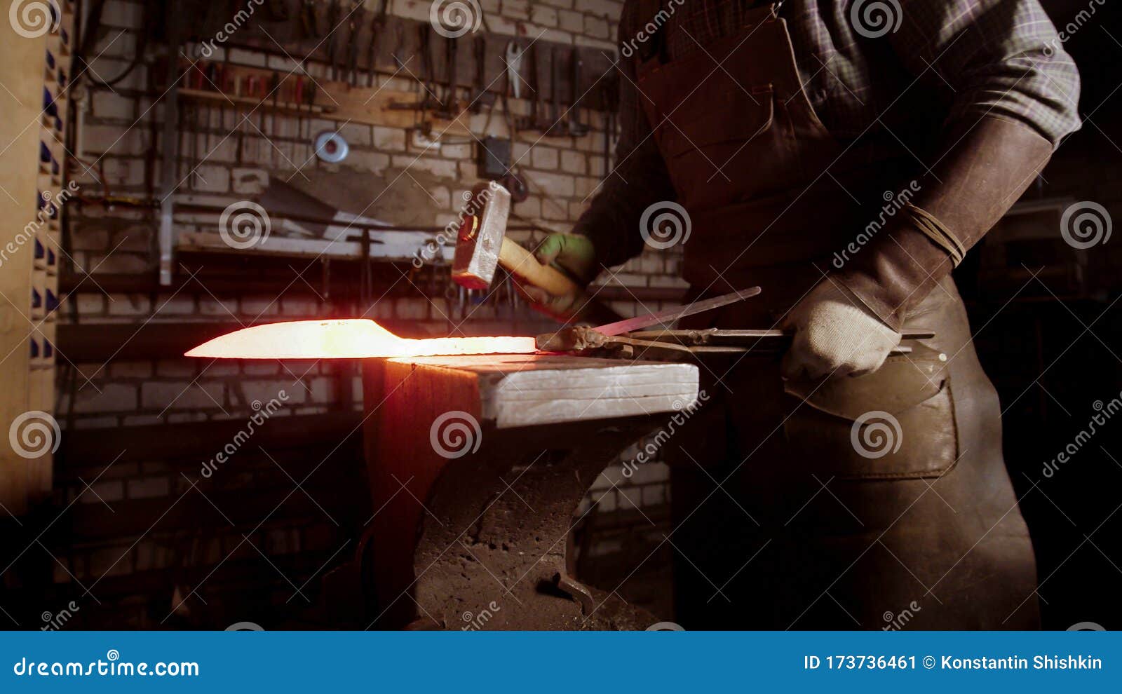 A Man Blacksmith a Hot Knife Blade Using a Hammer Stock Image