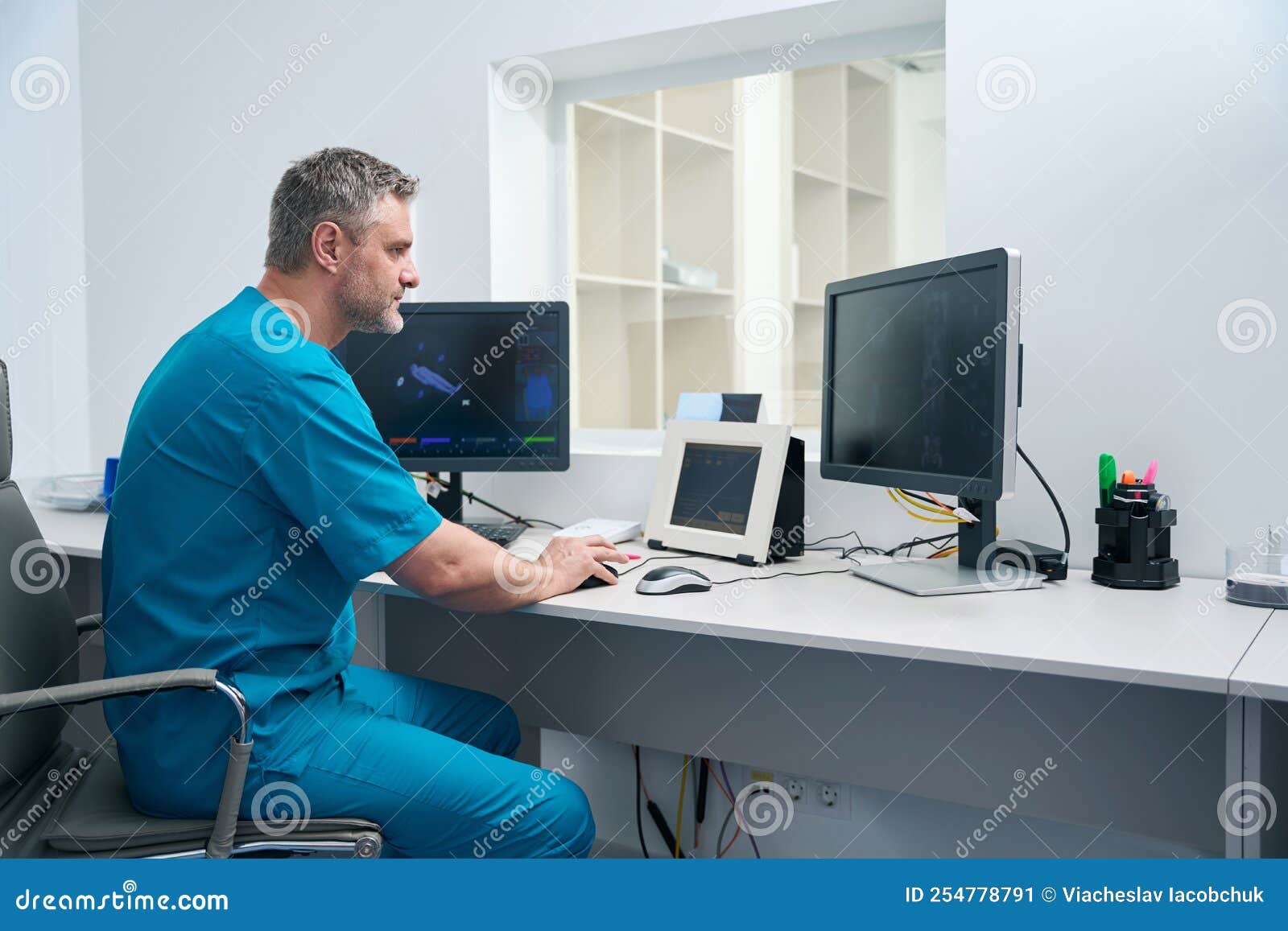 Man in Blue Medical Overalls Works at a Table Stock Image Image of