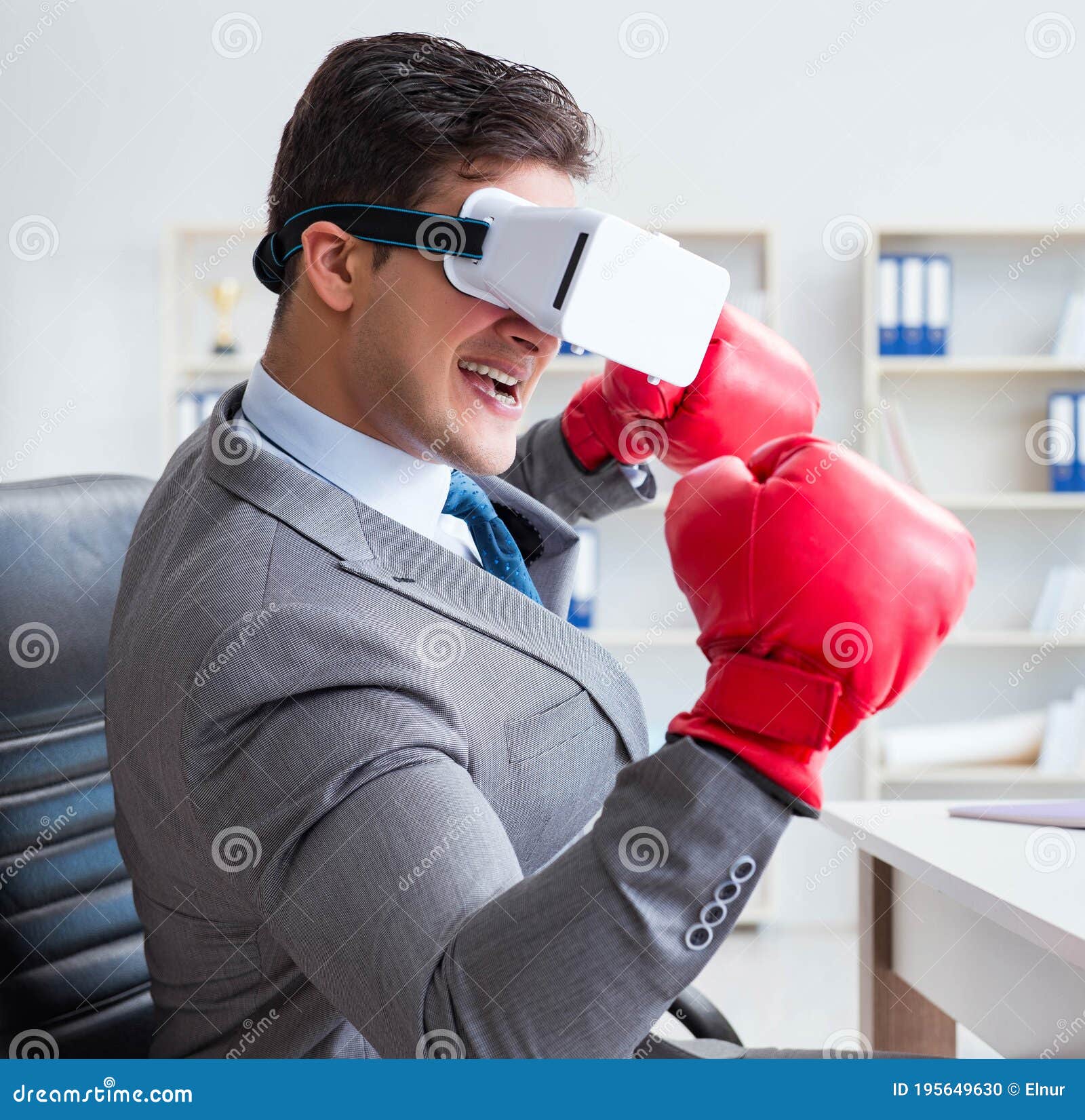 Man Boxing in the Office with Virtual Reality Goggles Stock Photo