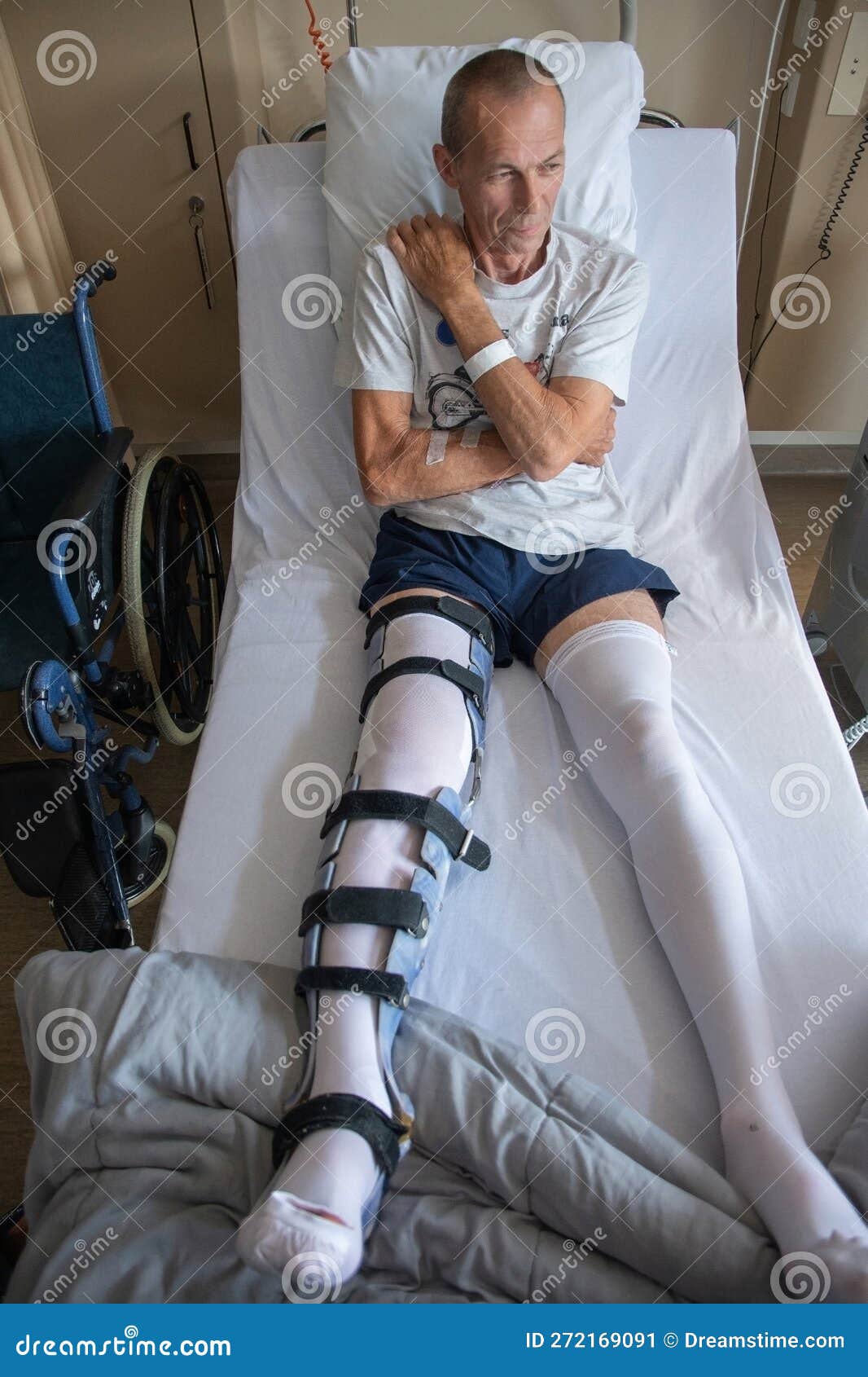 A Man with a Broken Leg in an Orthese in Bed in a Clinic after an
