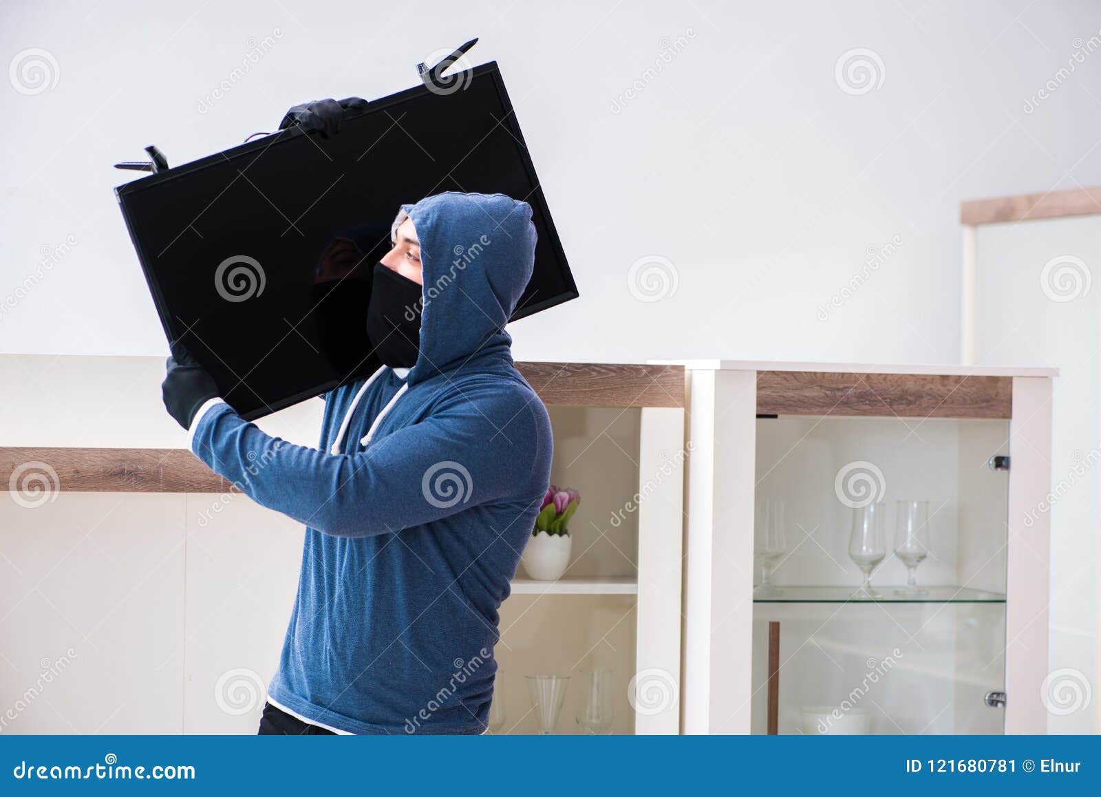 the man burglar stealing tv set from house
