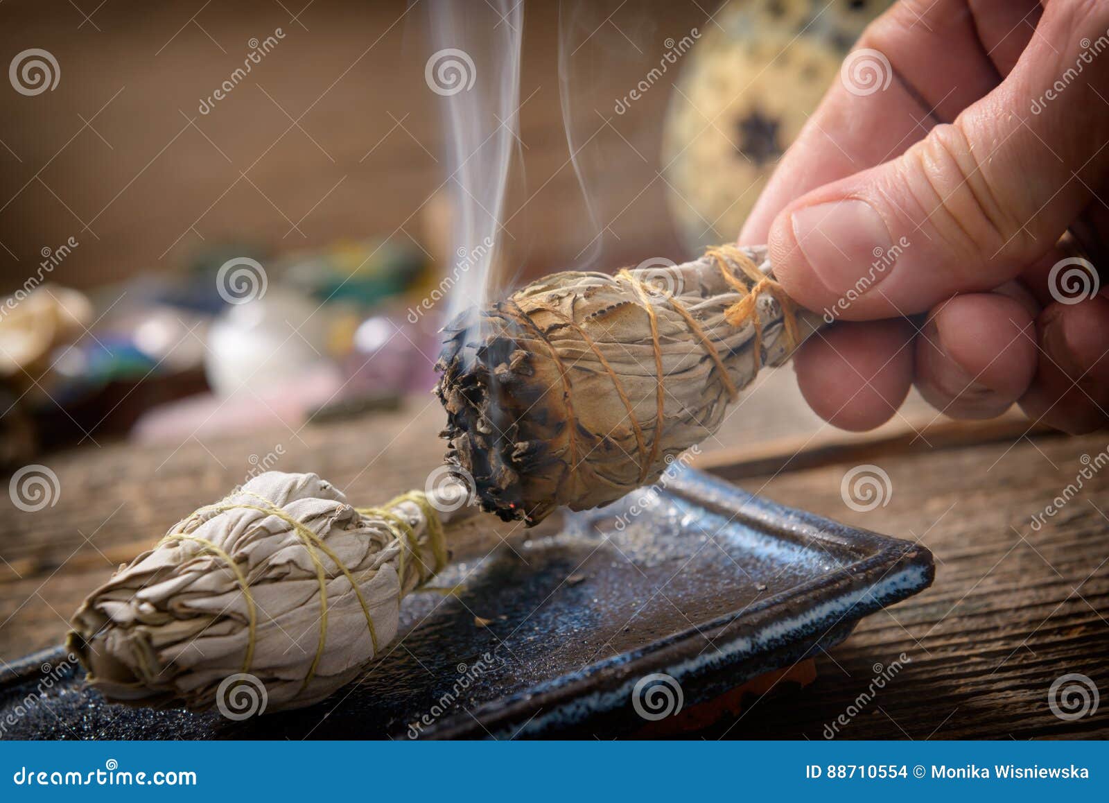 man burning white sage incense