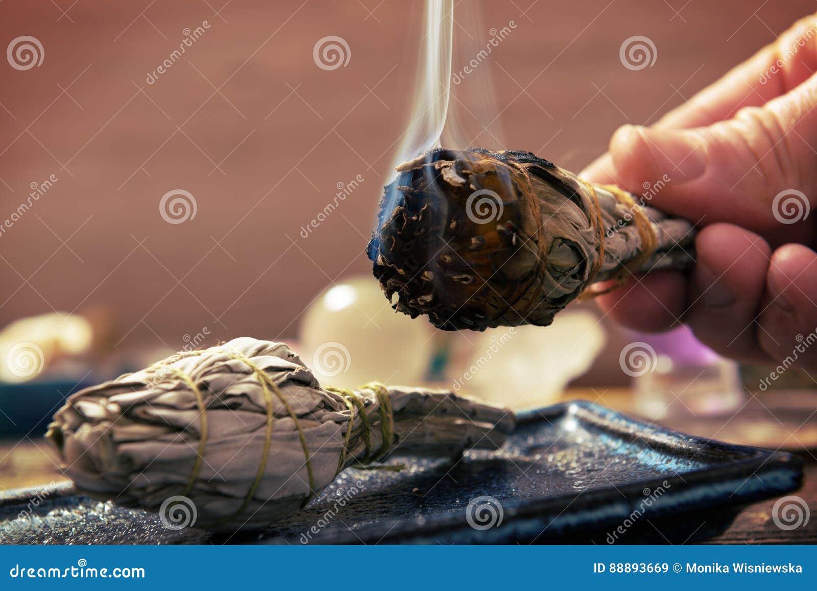 man burning white sage incense