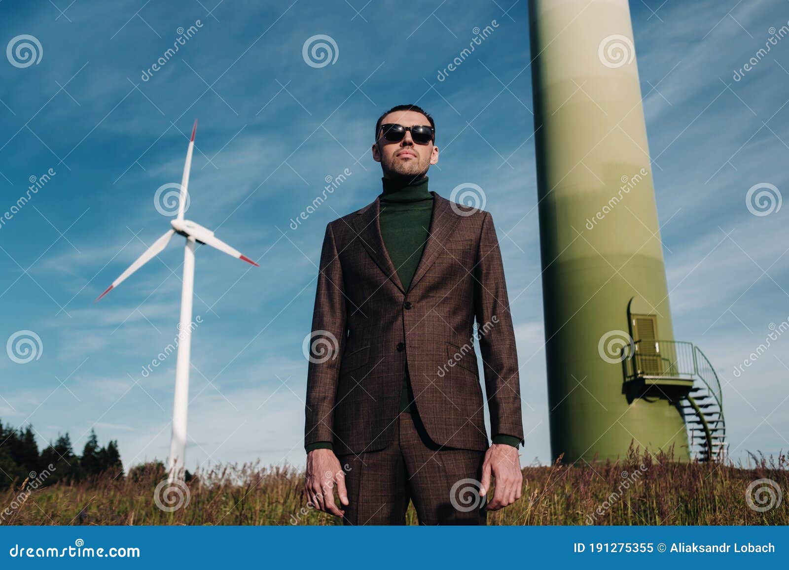 A Man in a Business Suit with a Green Golf Shirt Stands Next To a ...