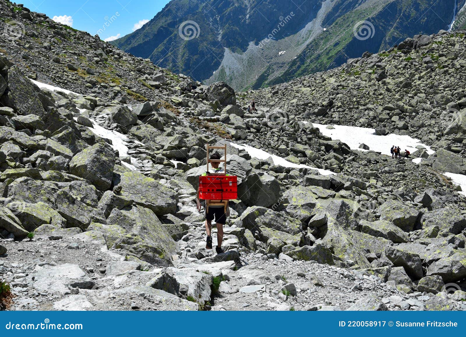 a man carrying boxes down from the mountain lodge chata pod rysmi near mount rysy, high tatras, slovakia