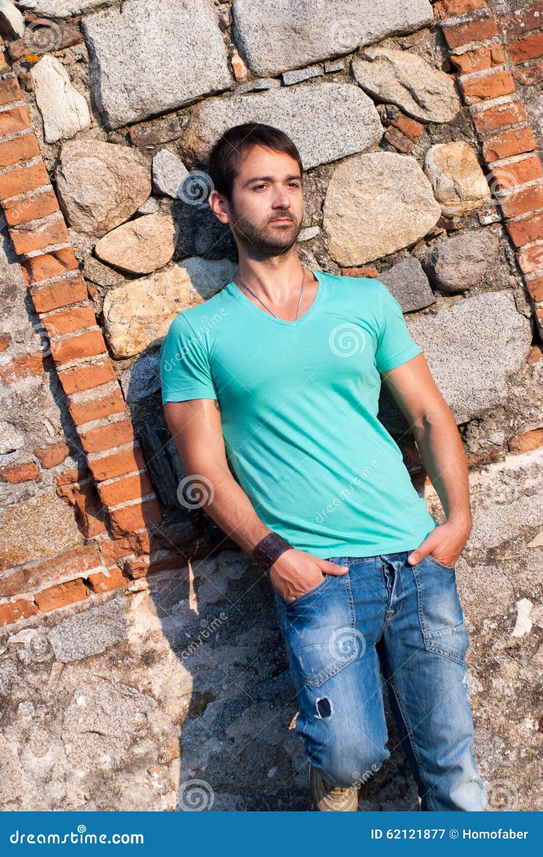 Man in Casual Clothes Stands Against a Brick Rock Wall Stock Image ...