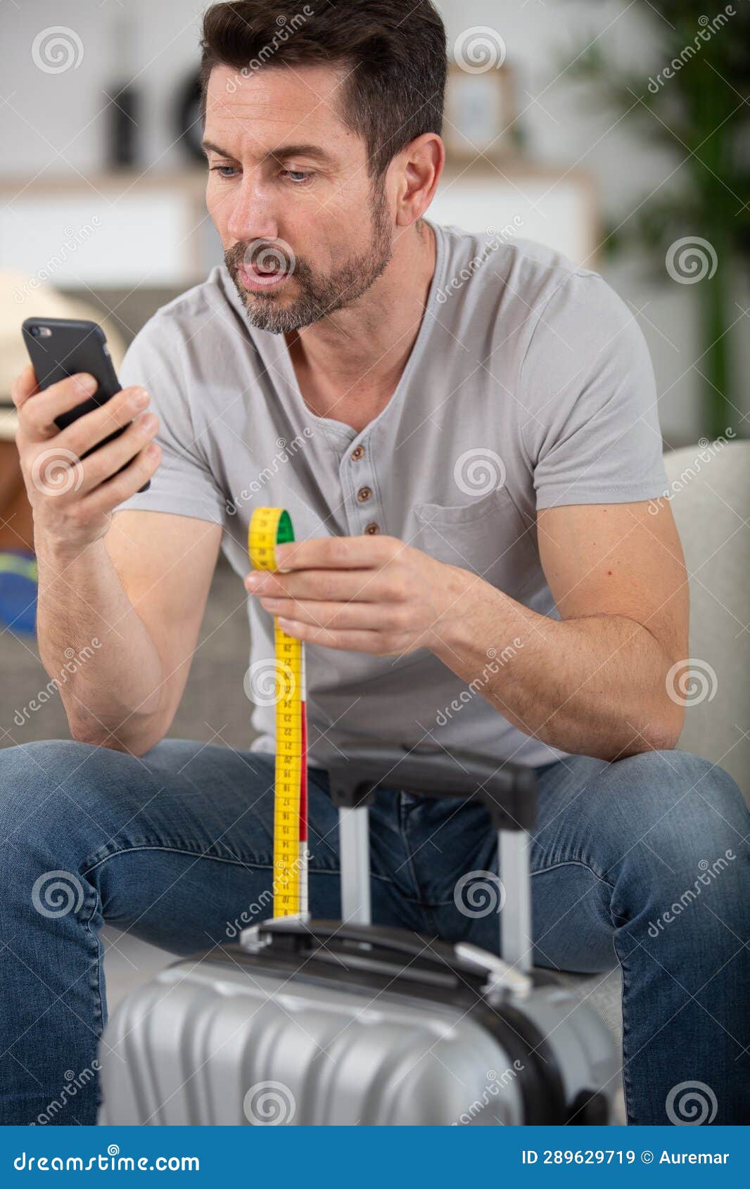 Man Checking Hand Luggage Size Online Stock Image Image of indoors