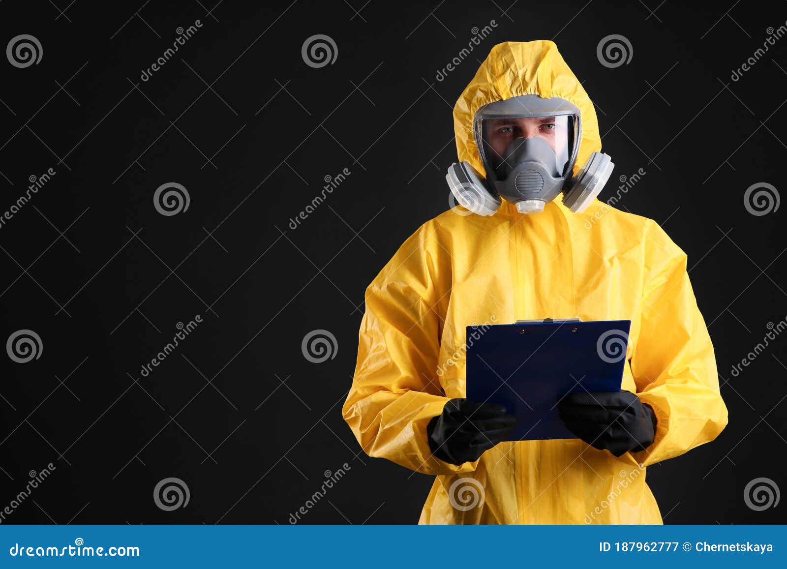 Man in Chemical Protective Suit Holding Clipboard on Background, Space ...