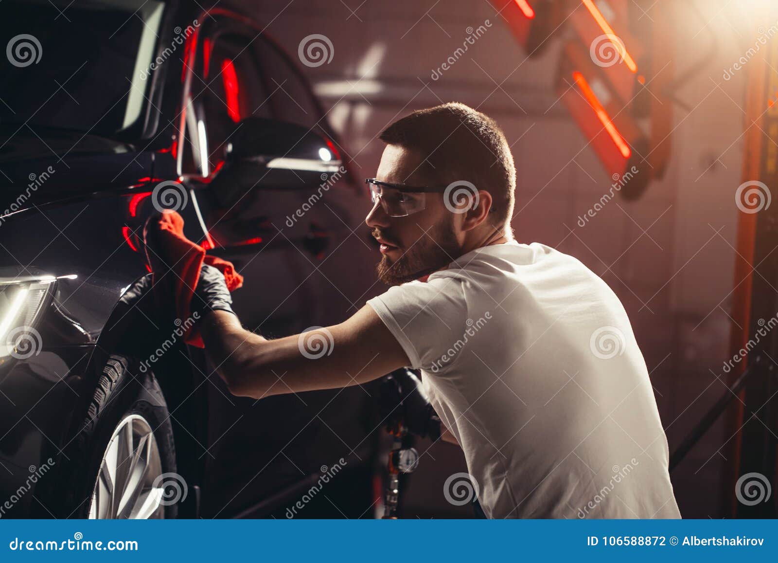 man cleaning car with microfiber cloth, car detailing or valeting concept