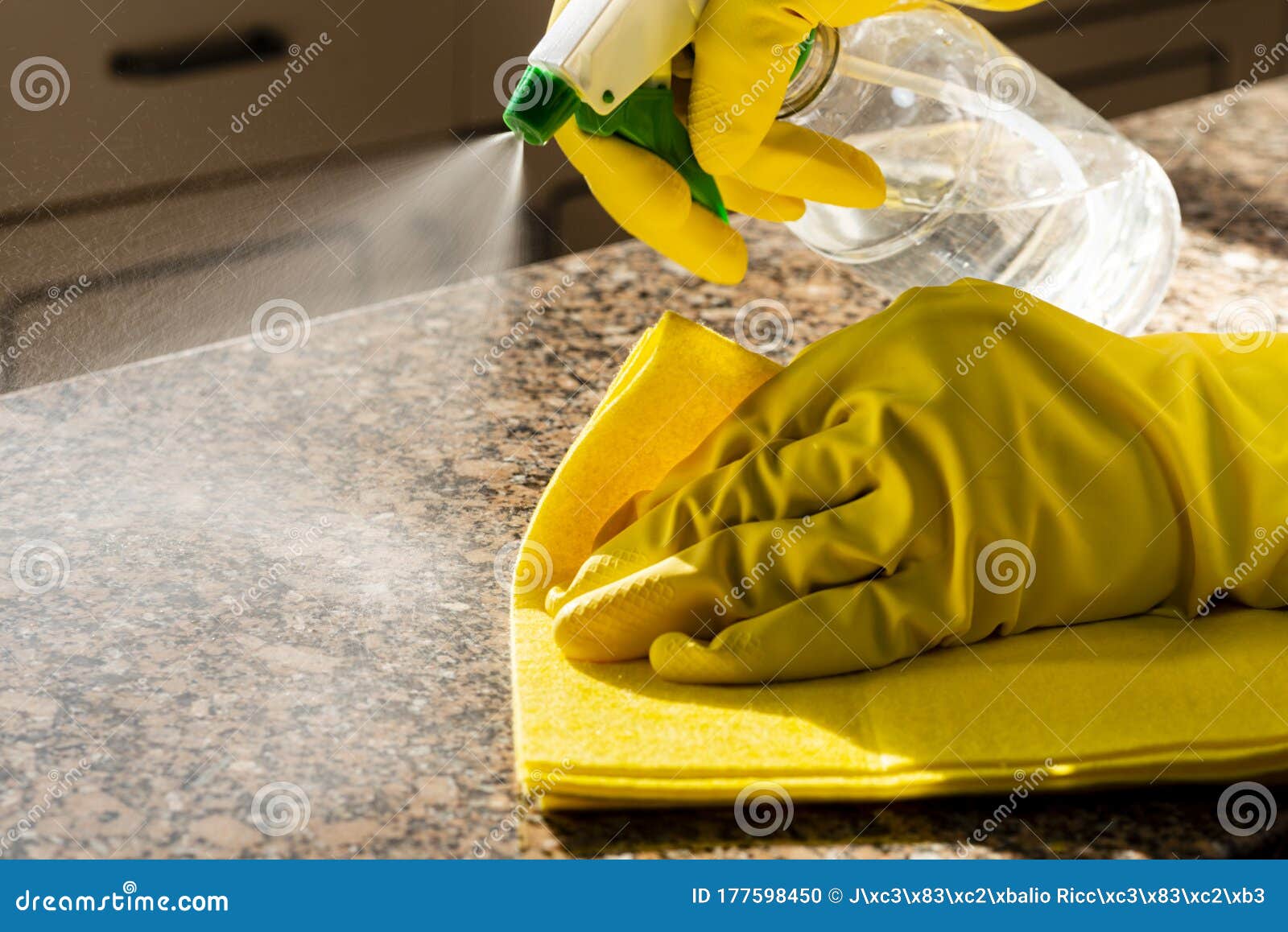 Man Cleaning Kitchen Counter with Solution To Kill Viruses and Bacteria