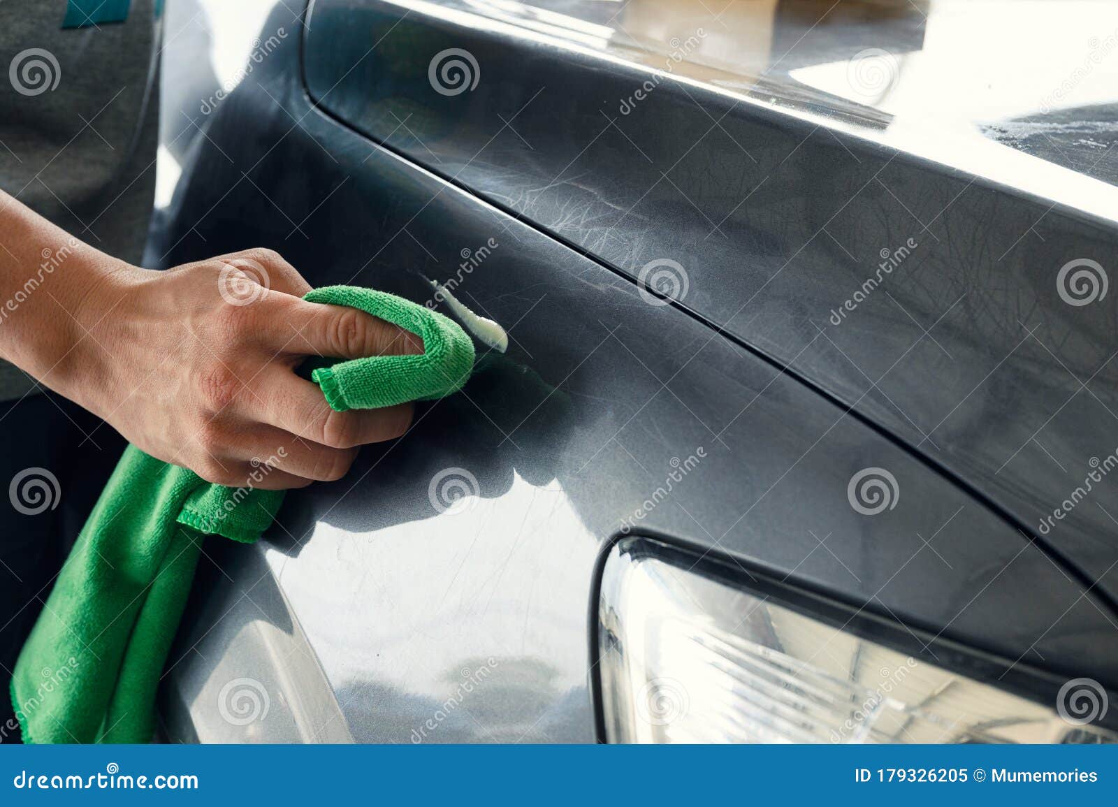 Man Cleaning Scratch on Car with Microfiber Cloth and Cleaner Remover