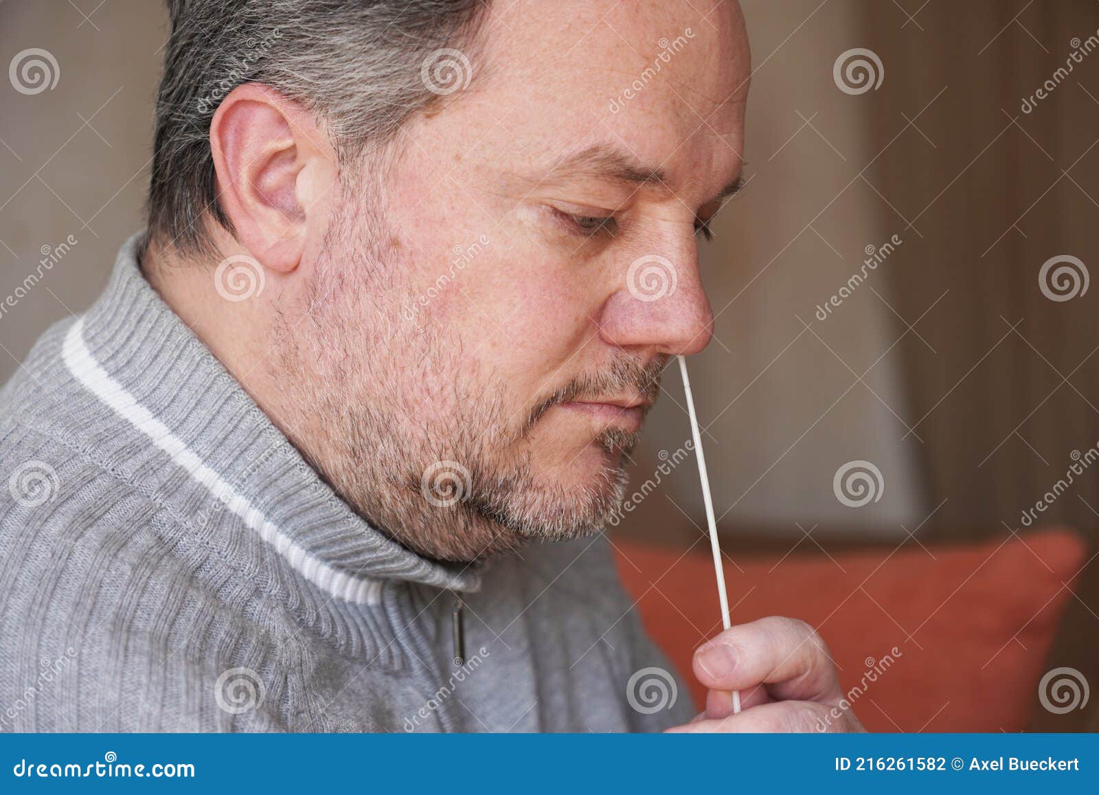 man collecting nasal mucus sample from nose with cotton swab for covid-19 coronavirus self testing at home