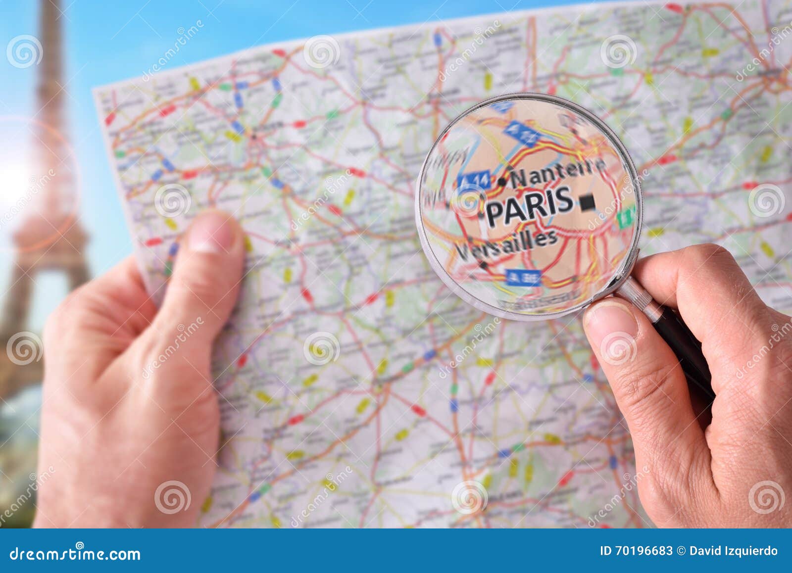 man consulting a map of paris with a magnifying glass