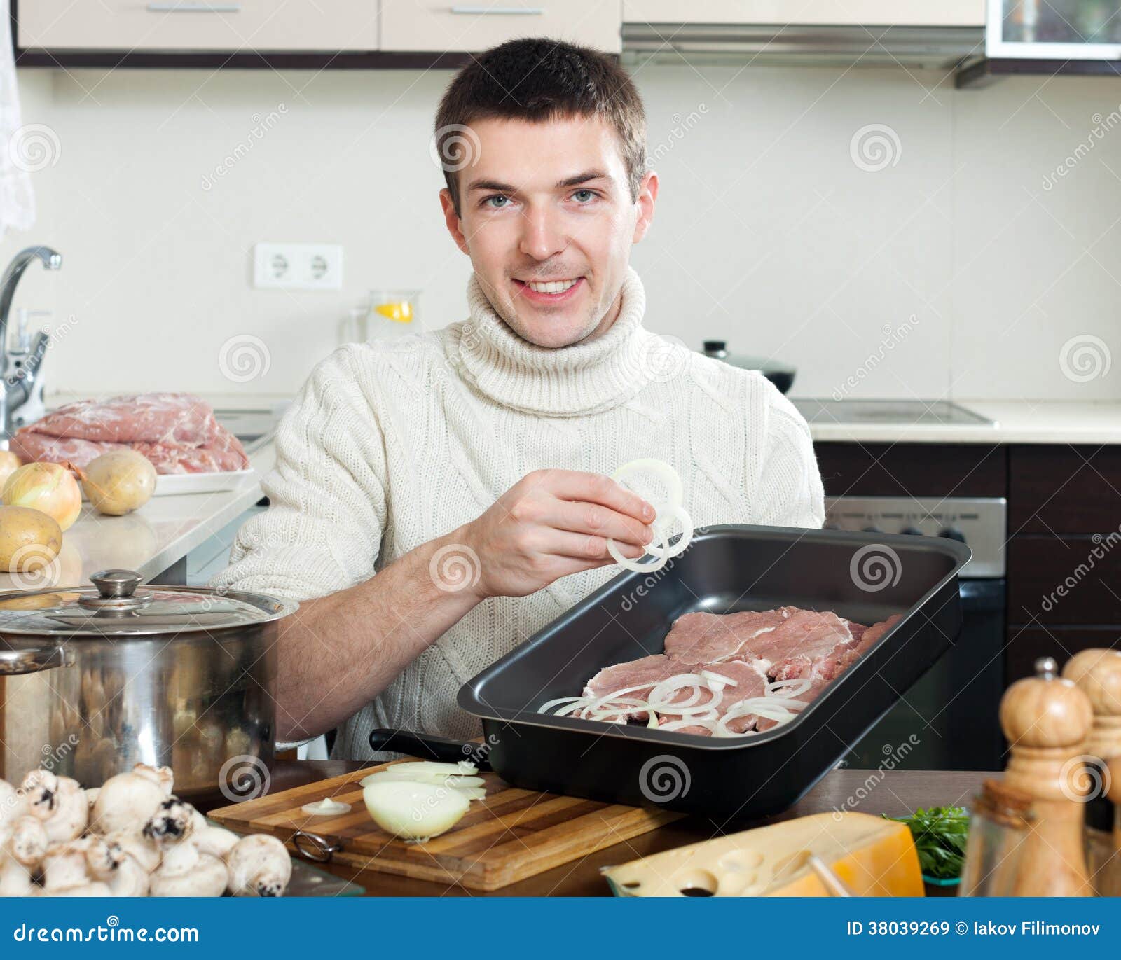 Man Cooking Frenchstyle Meat. Adding Onion in Roasting Pan Stock Image