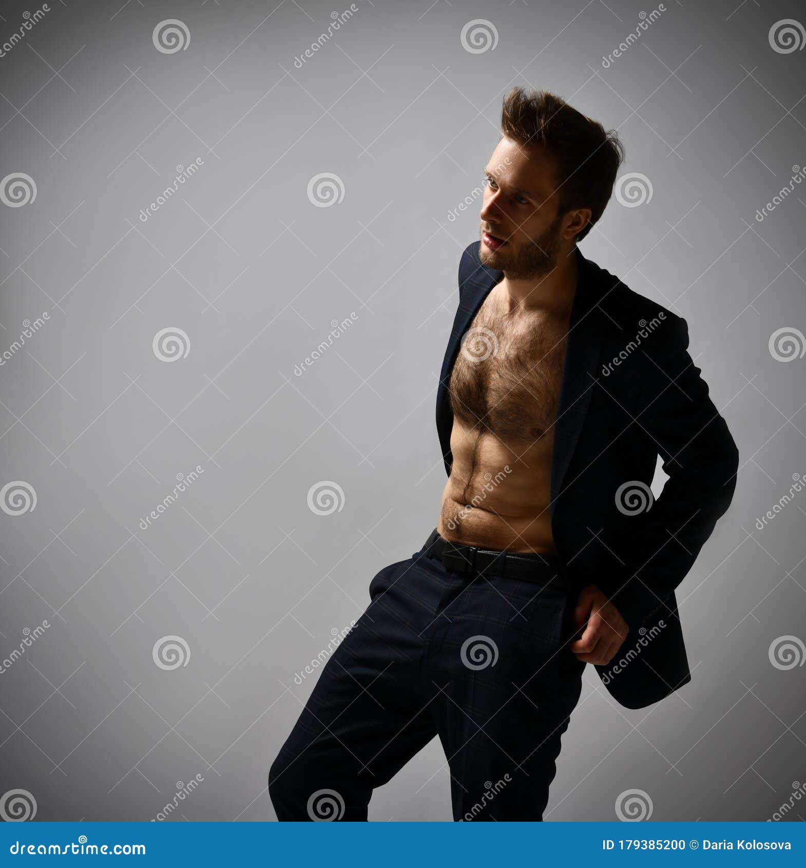 Man with Cool Hairstyle, in Black Suit on Naked Body. he Putting Hands in  Pockets, Posing Sideways on Gray Background. Close Up Stock Photo - Image  of athlete, hairstyle: 179385200
