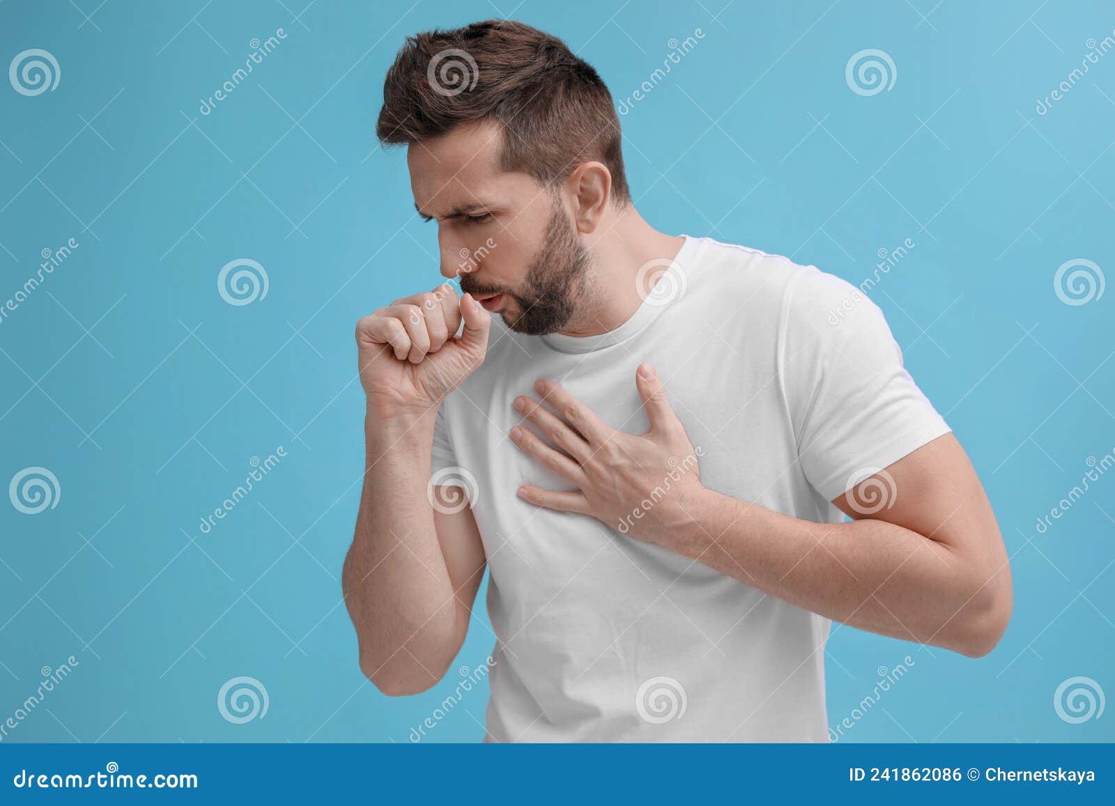 Man Coughing on Light Blue Background. Cold Symptoms Stock Photo