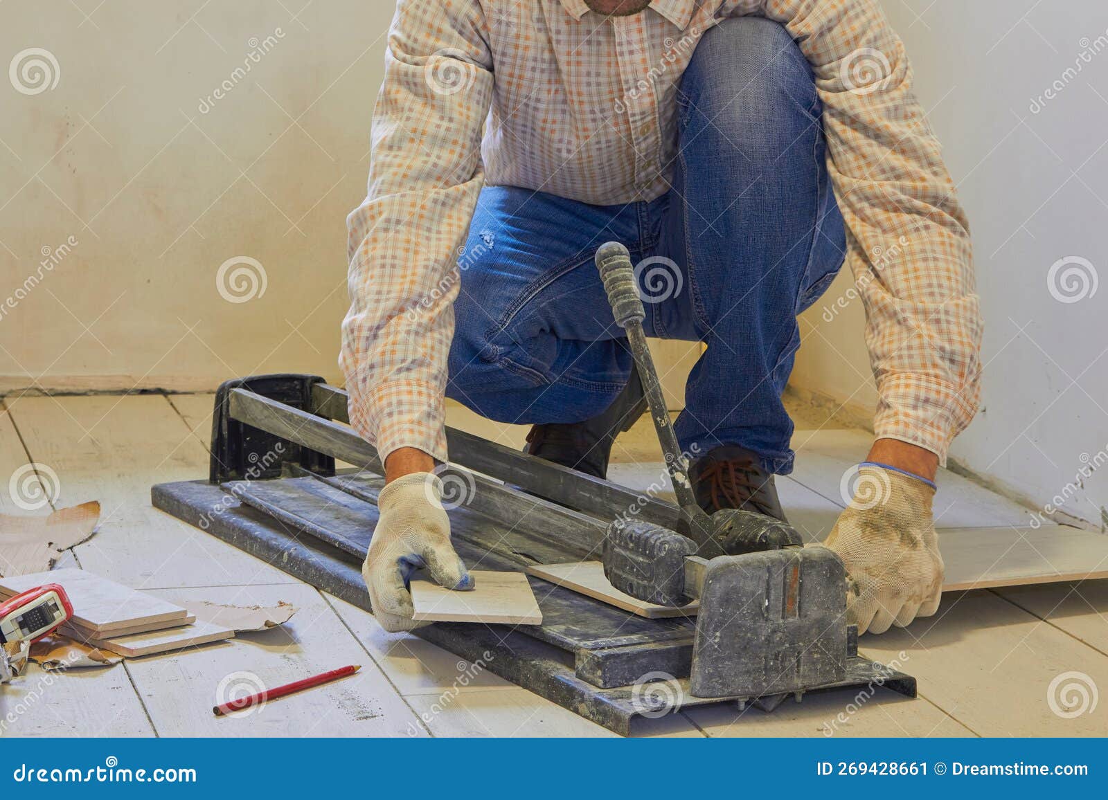 A Man is Cutting a Ceramic Tile with a Tile Cutter,the Work of a