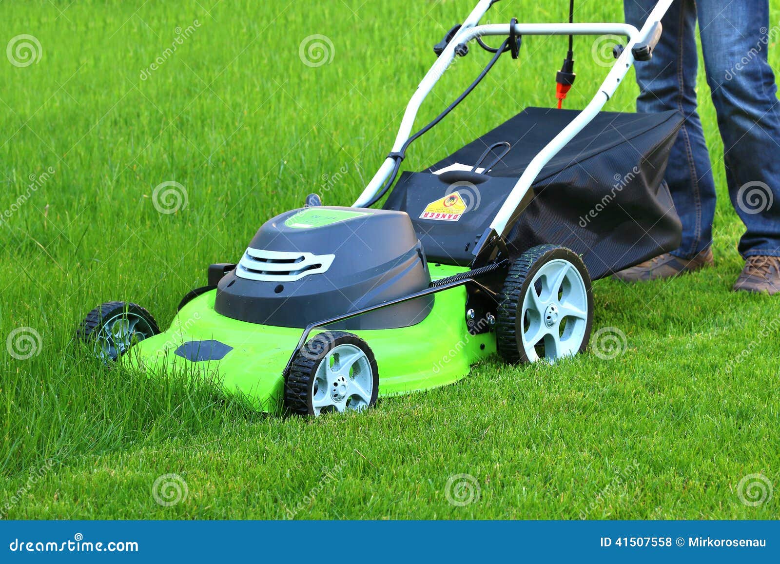 man cutting the grass with lawn mower
