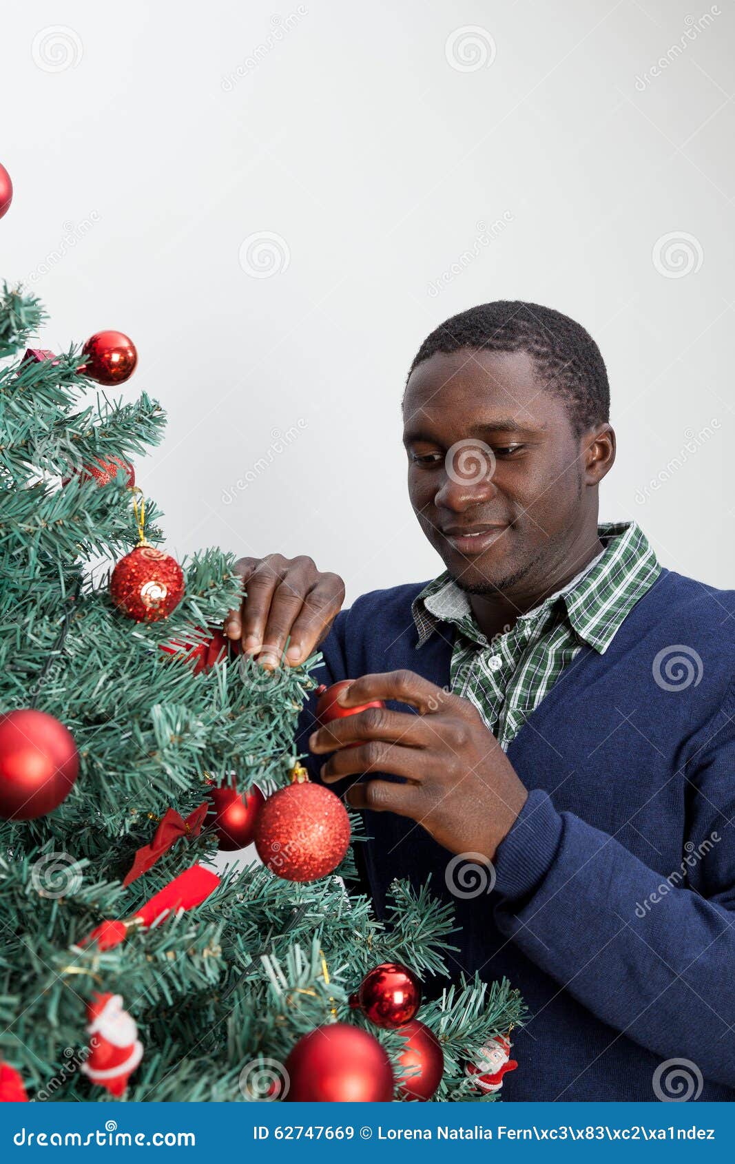 Man Decorating the Christmas Tree and Looking at Camera Stock Image