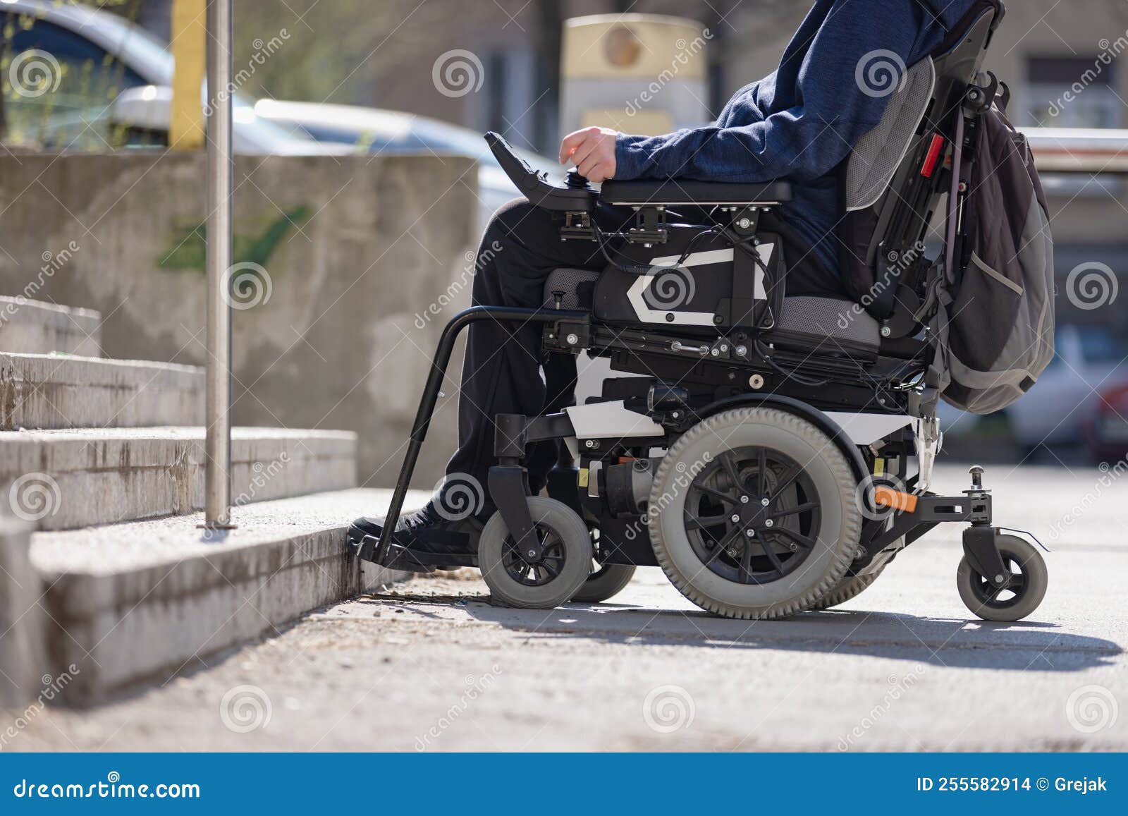 Man with Disability on Wheelchair Stopped in Front of Staircase Stock