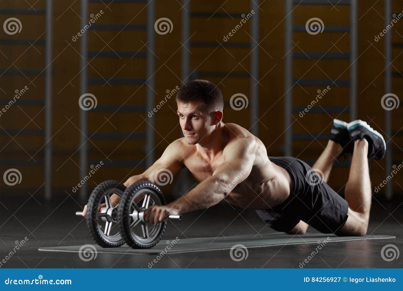 Man Doing Sport Exercise On Floor With Toning Wheel Stock Image