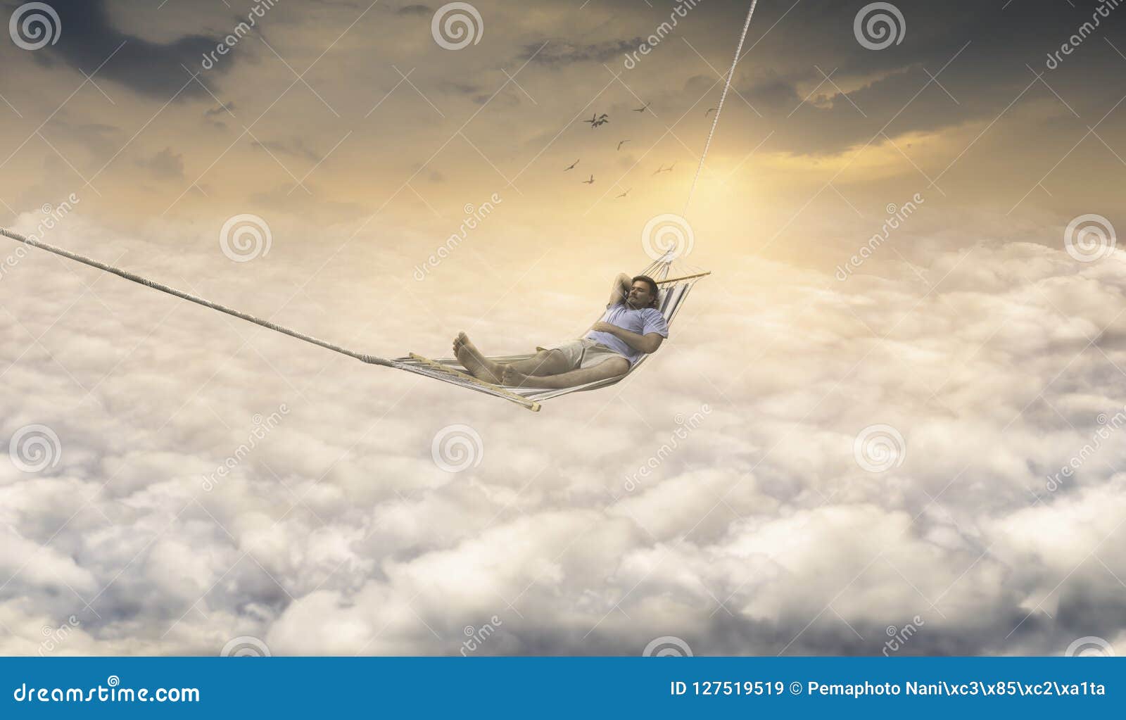 man dreaming in rocking net above sky