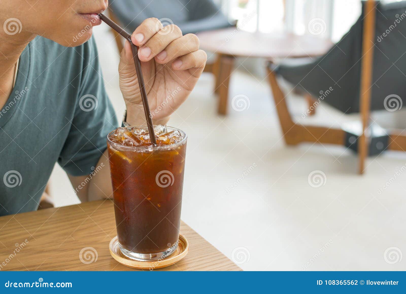 man drinking a glass of ice americano.