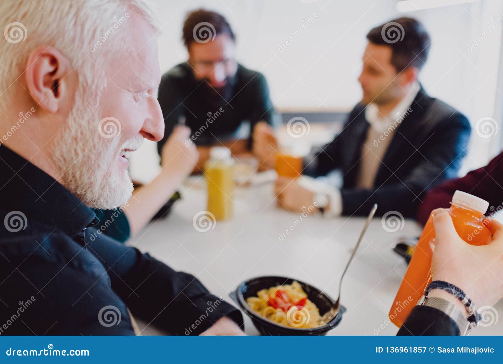 Man Drinking Organic Juice in the Office Cafeteria and Smiling Stock