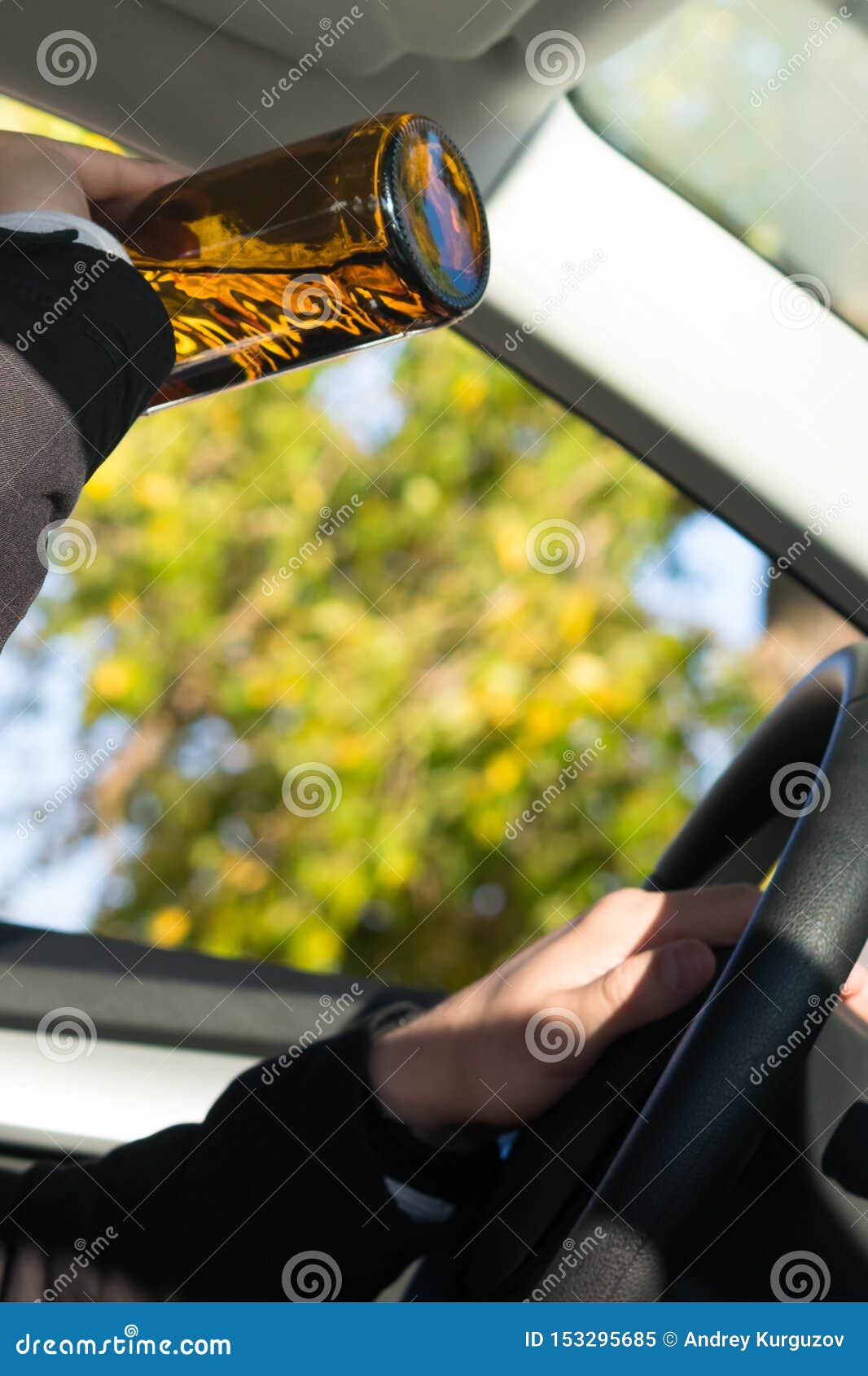 A Man Driving a Car Drinks an Alcoholic Drink from a Bottle Stock Image