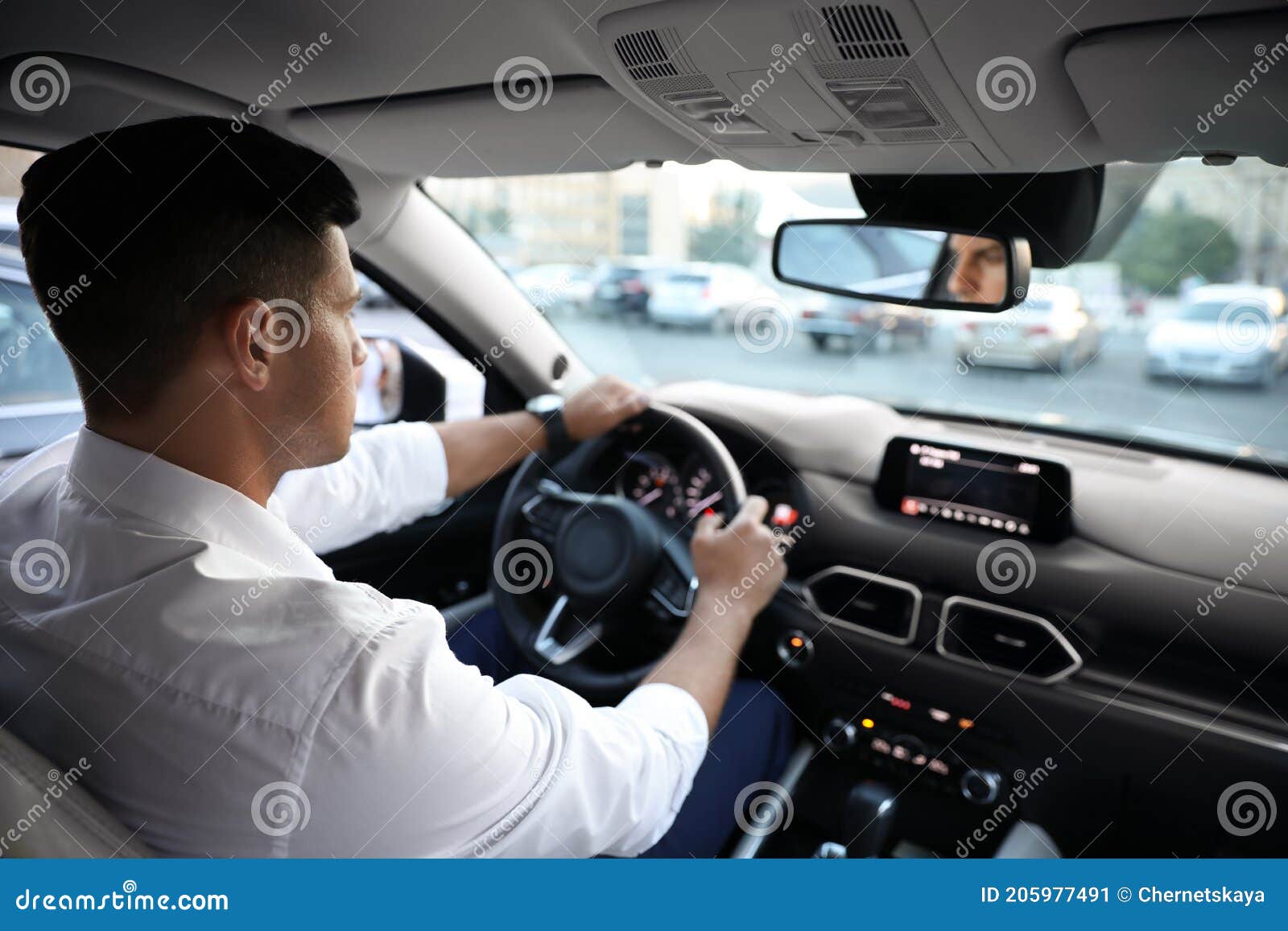 Man Driving His Modern Luxury Car, View from Backseat Stock Image