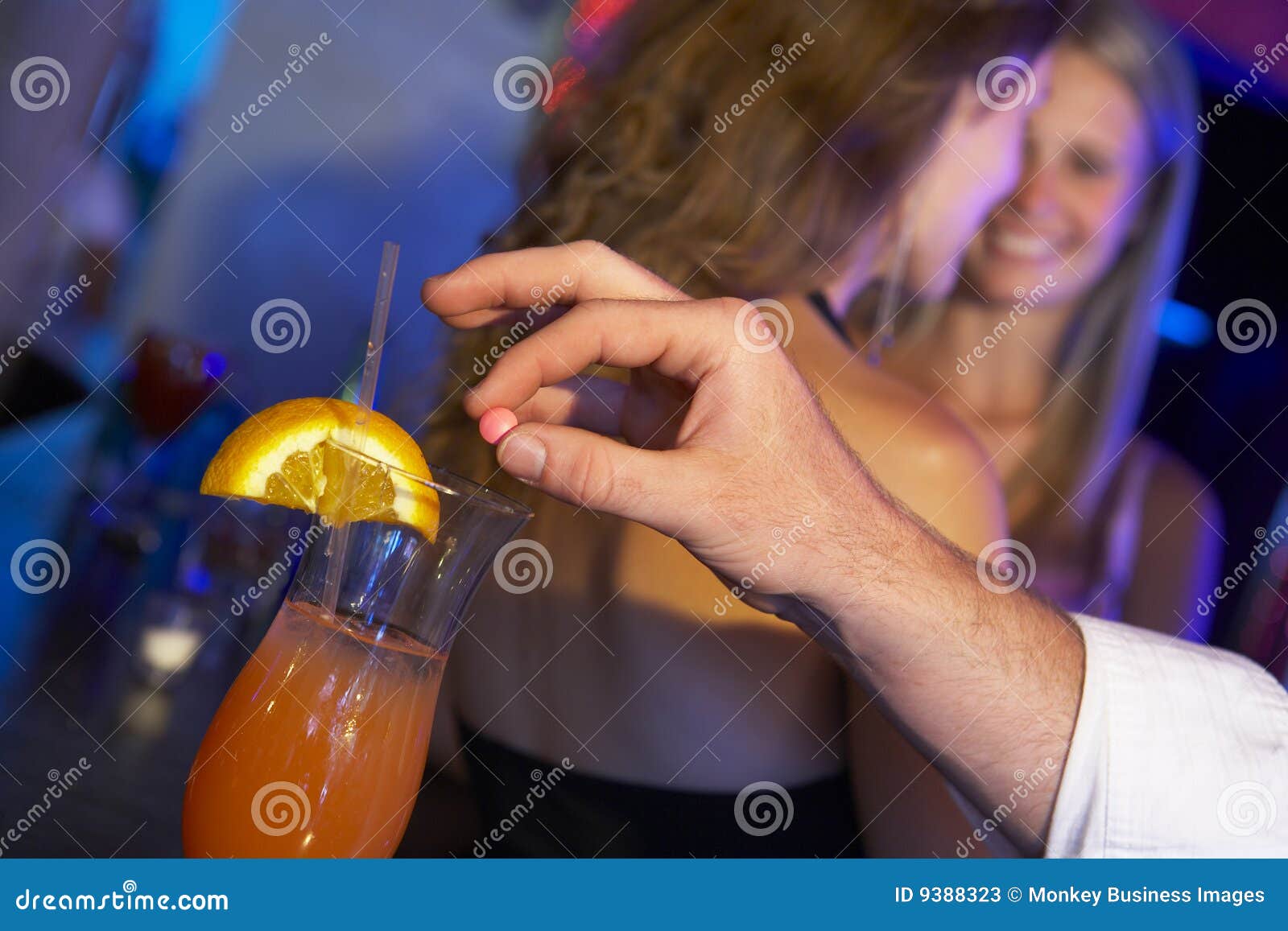 man drugging woman's drink in bar