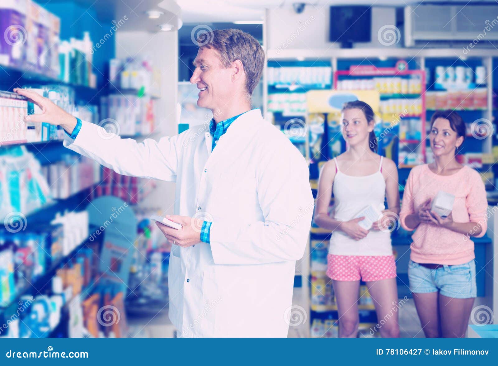 man druggist in white coat working in pharmacy
