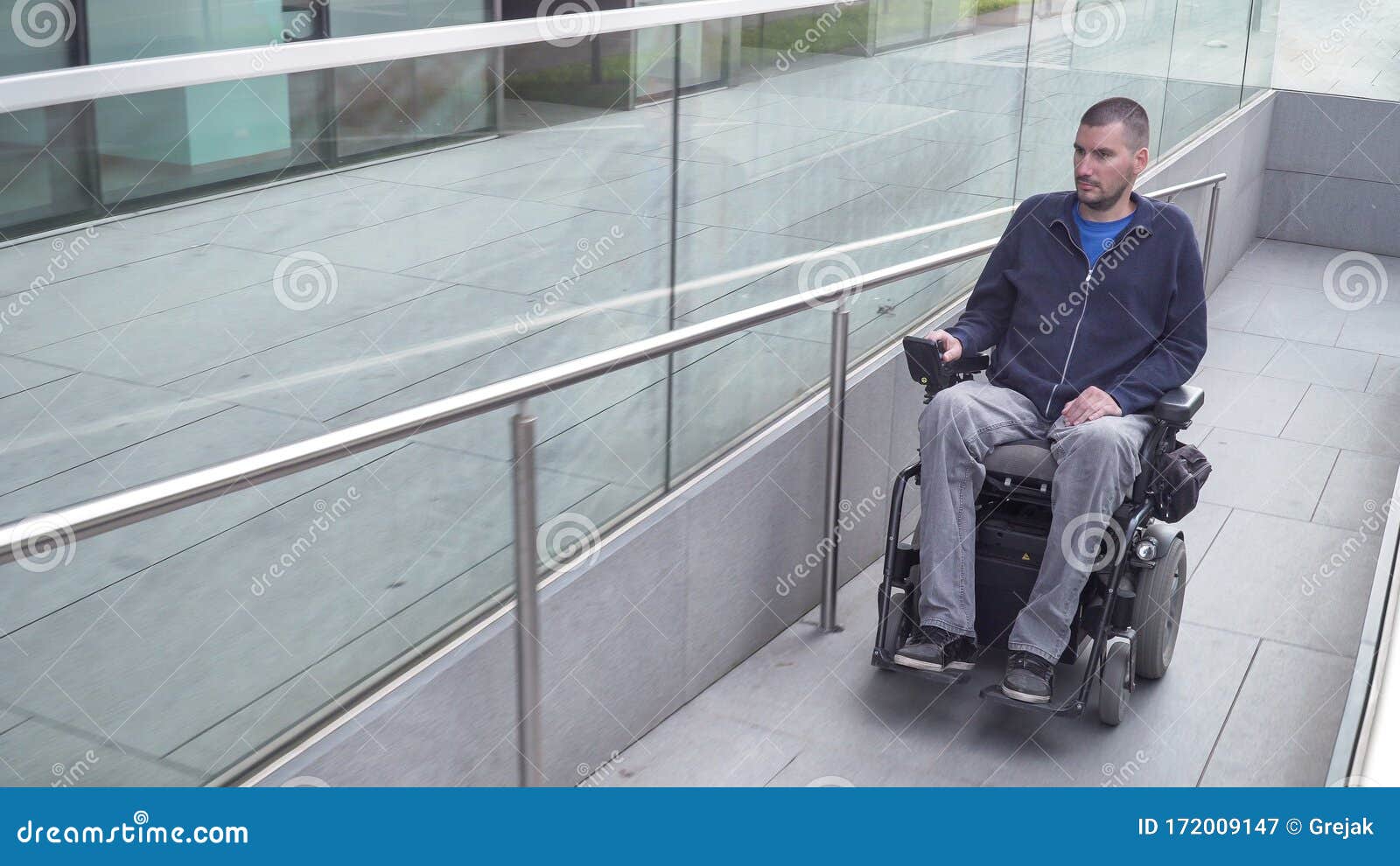man on electric wheelchair driving on a street. accessibility concept