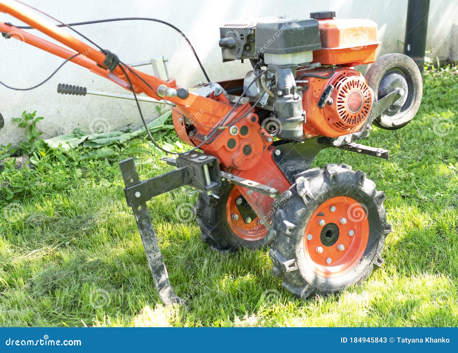 man farmer plows the land with a cultivator. agricultural machinery: cultivator for tillage in the garden,motor cultivator