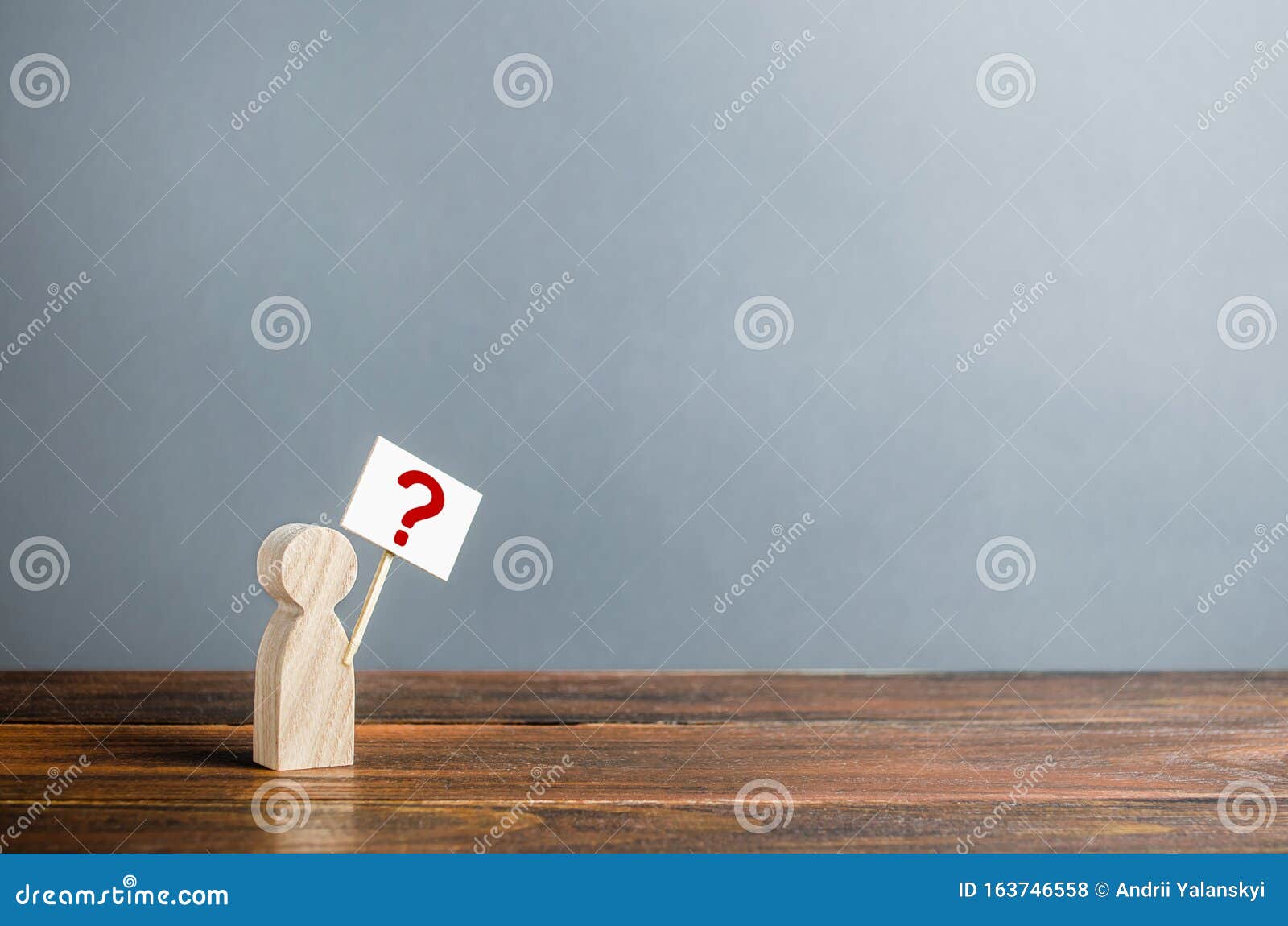 man figurine with a poster and a question mark. asking questions, searching for truth. curiosity, desire to learn more and improve