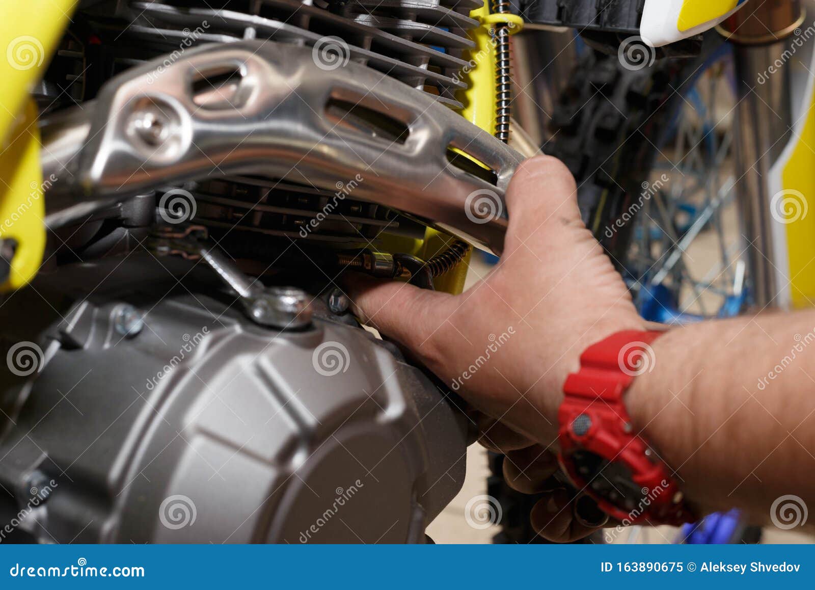 man fixing protection of exhaust of motorcicle