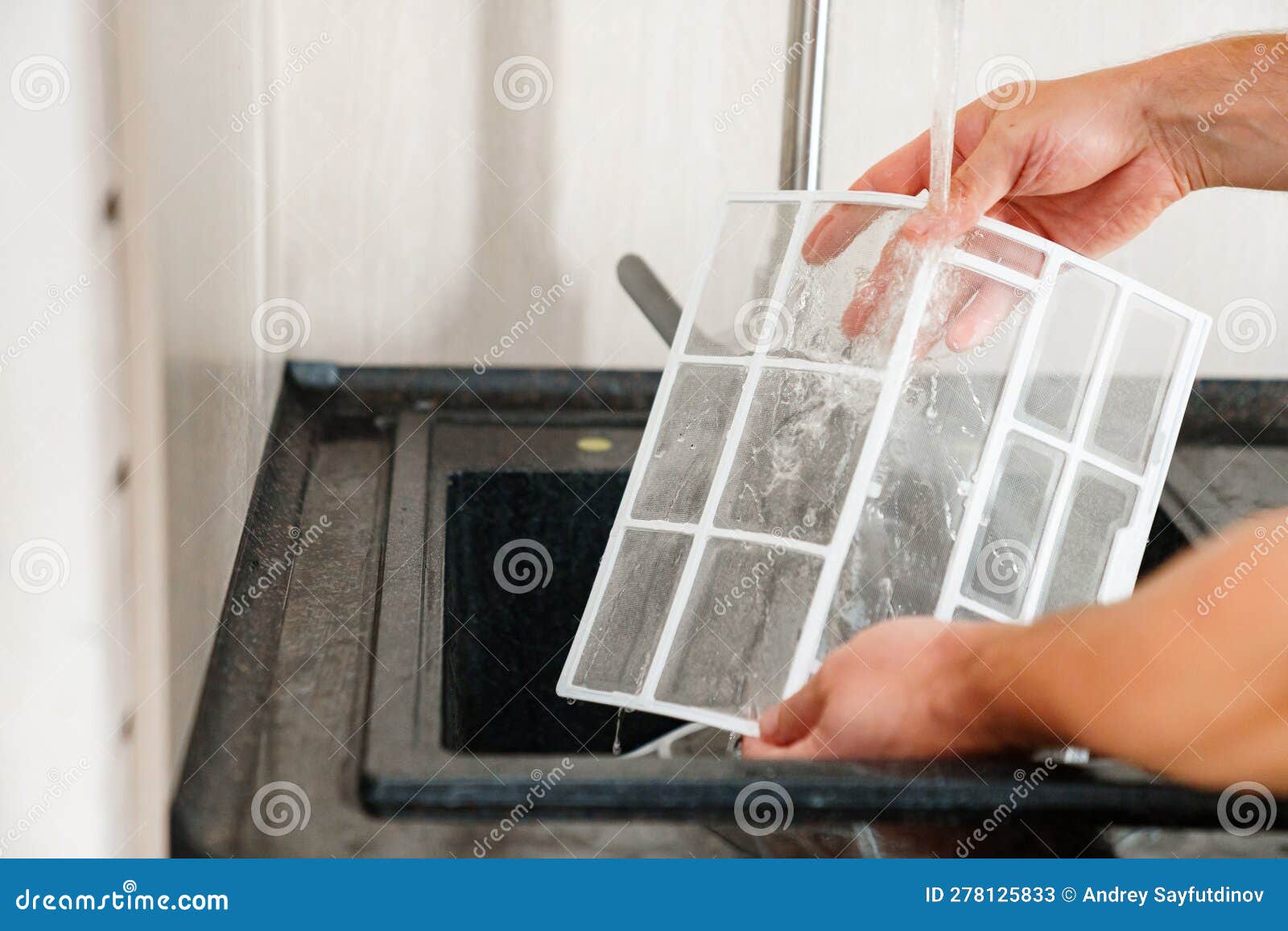 a man flushes the air cleaner filter from the air conditioner.